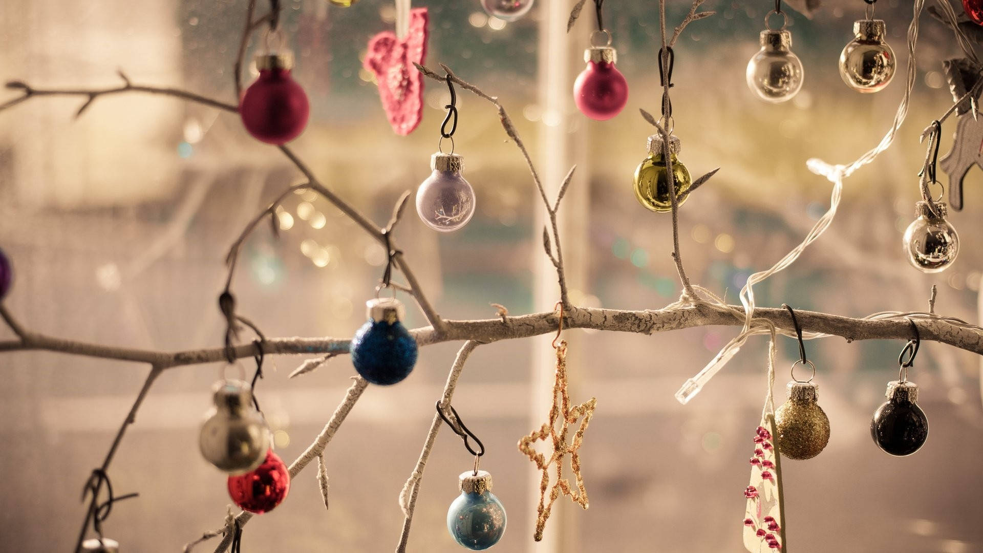 Christmas Balls 桌布 壁紙 — 色彩繽紛的裝飾品和童話燈從光禿禿的冬季樹枝上垂下來，背景柔和模糊。