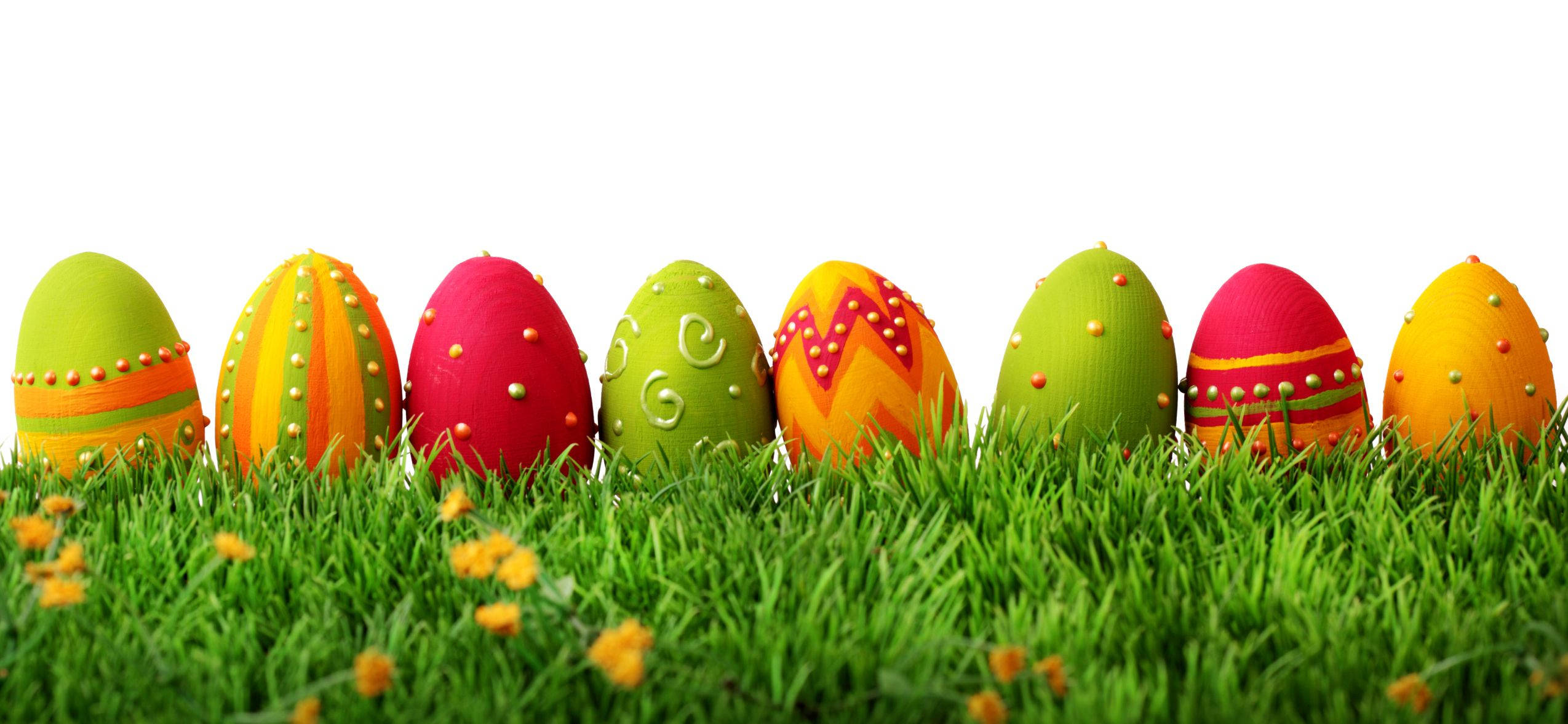 Happy Easter 桌布 壁紙 — 色彩繽紛的裝飾復活節蛋 nestled 在茂密的綠草中，伴隨著小黃花。