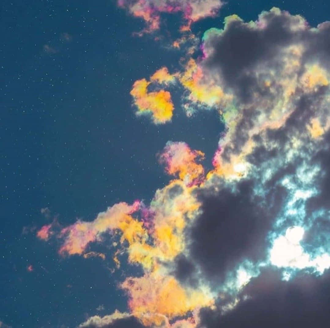 夜空 桌布 壁紙 — 色彩繽紛的雲朵在繁星點點的夜空中發光，一道明亮的天體光芒穿透而出。