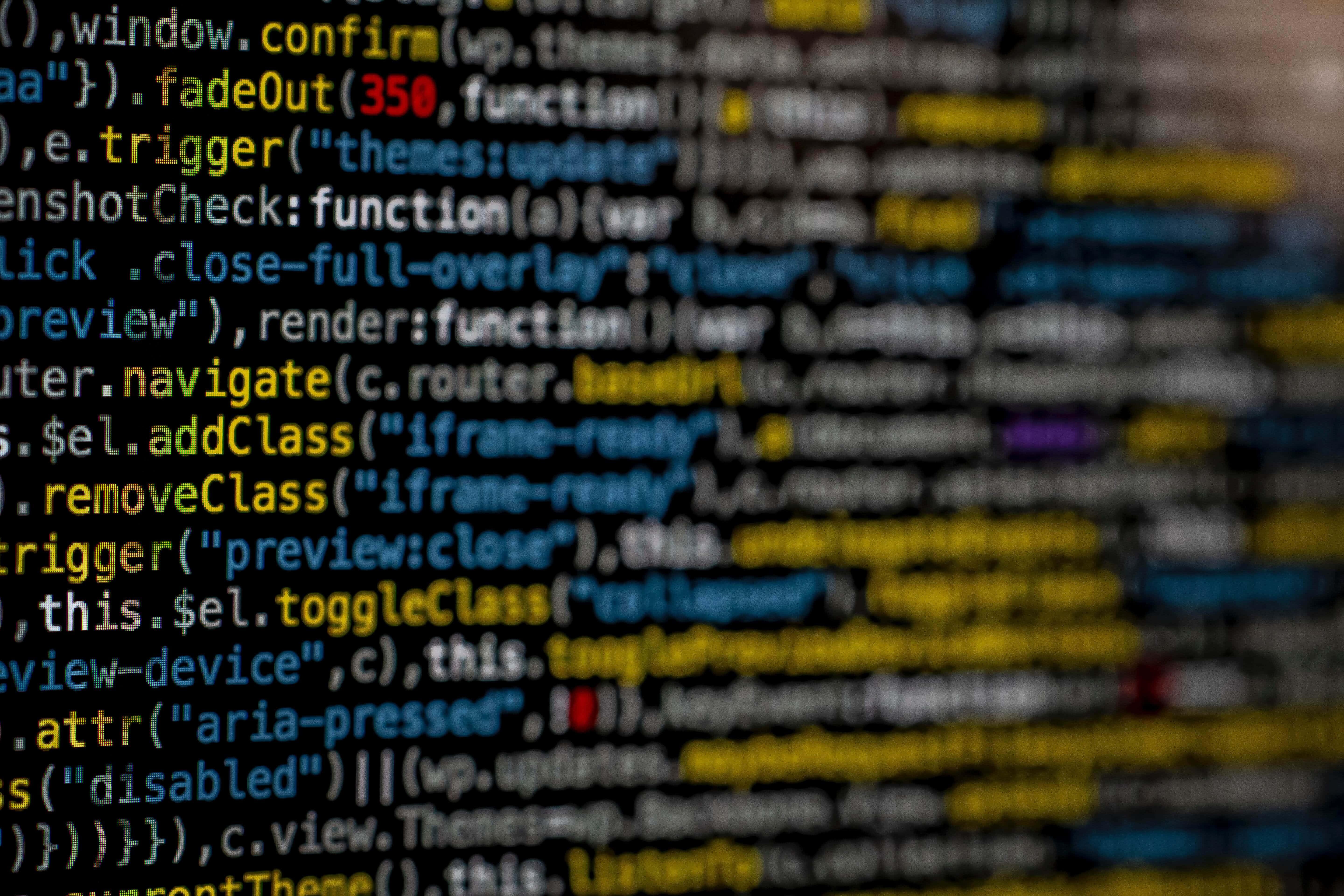 Code 桌布 壁紙 — 色彩繽紛的電腦代碼模糊線條在黑暗螢幕上以淺景深滾動。