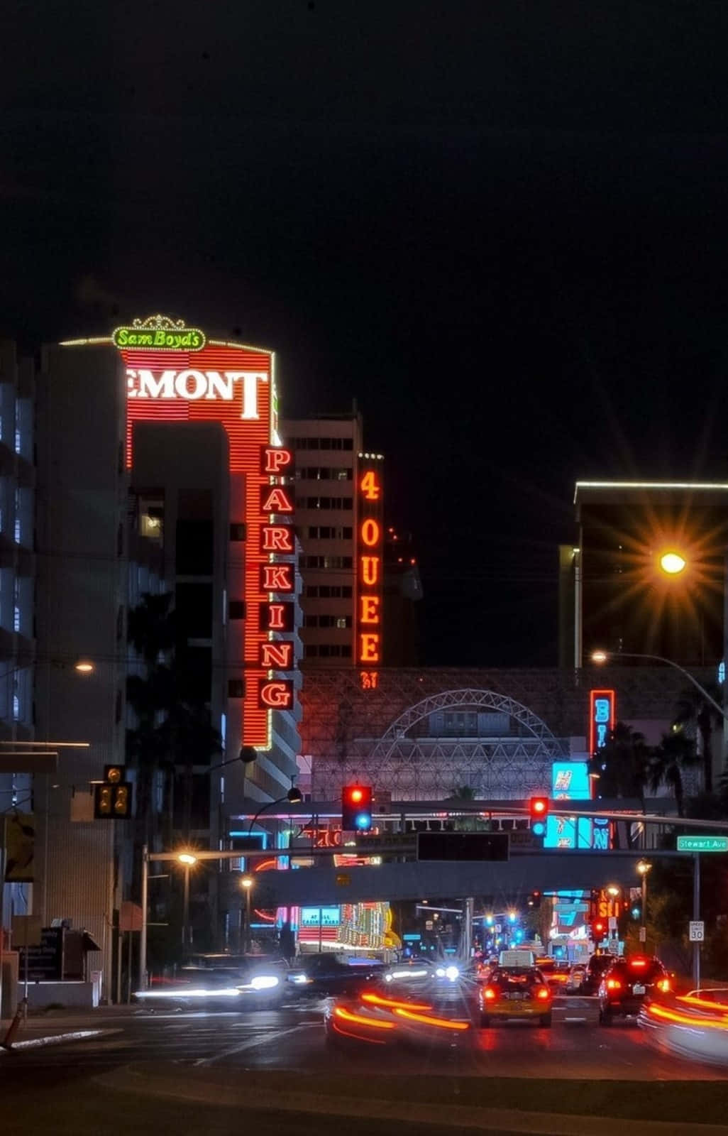 Las Vegas Phone 桌布 壁紙 — 色彩繽紛的霓虹燈照亮了繁忙的街道，車燈劃過，高樓聳立。