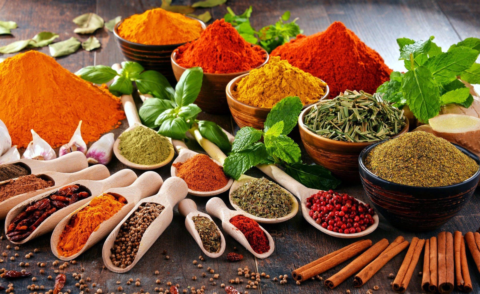 Spice 桌布 壁紙 — 色彩繽紛的香料和新鮮香草在質樸的木質表面上藝術地排列。