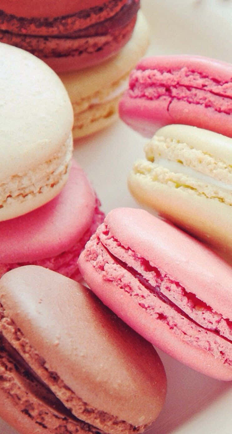 Macarons 桌布 壁紙 — 色彩繽紛的馬卡龍以柔和粉彩色調近距離拍攝，誘人地擺放在白色表面上。