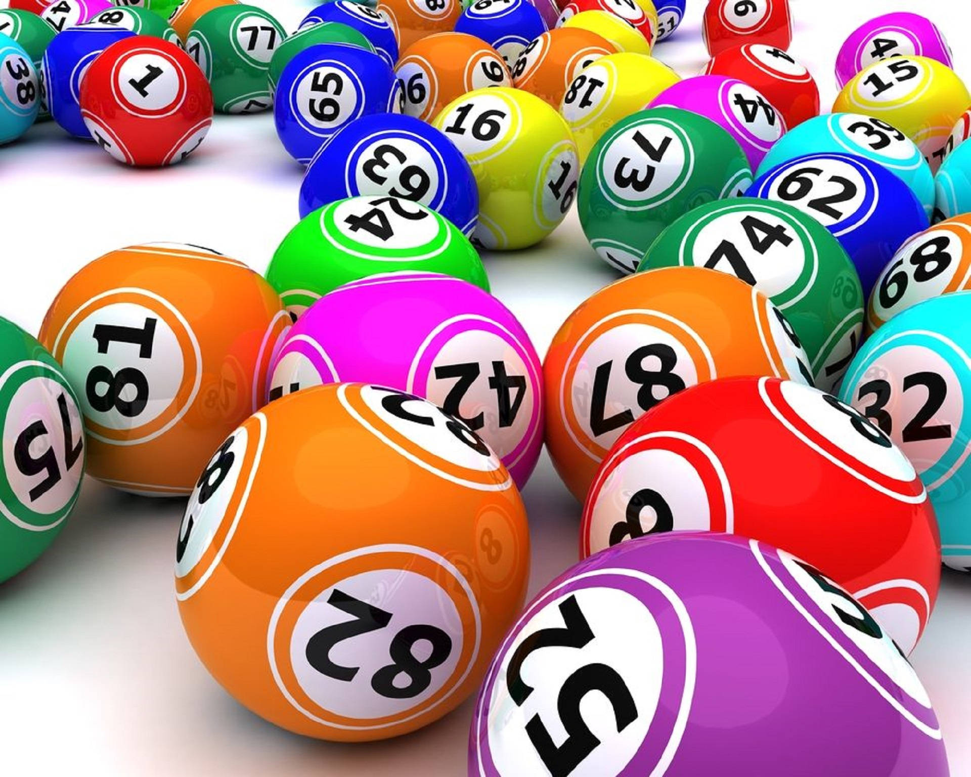 Bingo 桌布 壁紙 — 色彩鮮豔光澤的彩票球，帶有粗體數字，散落在明亮的白色表面上。