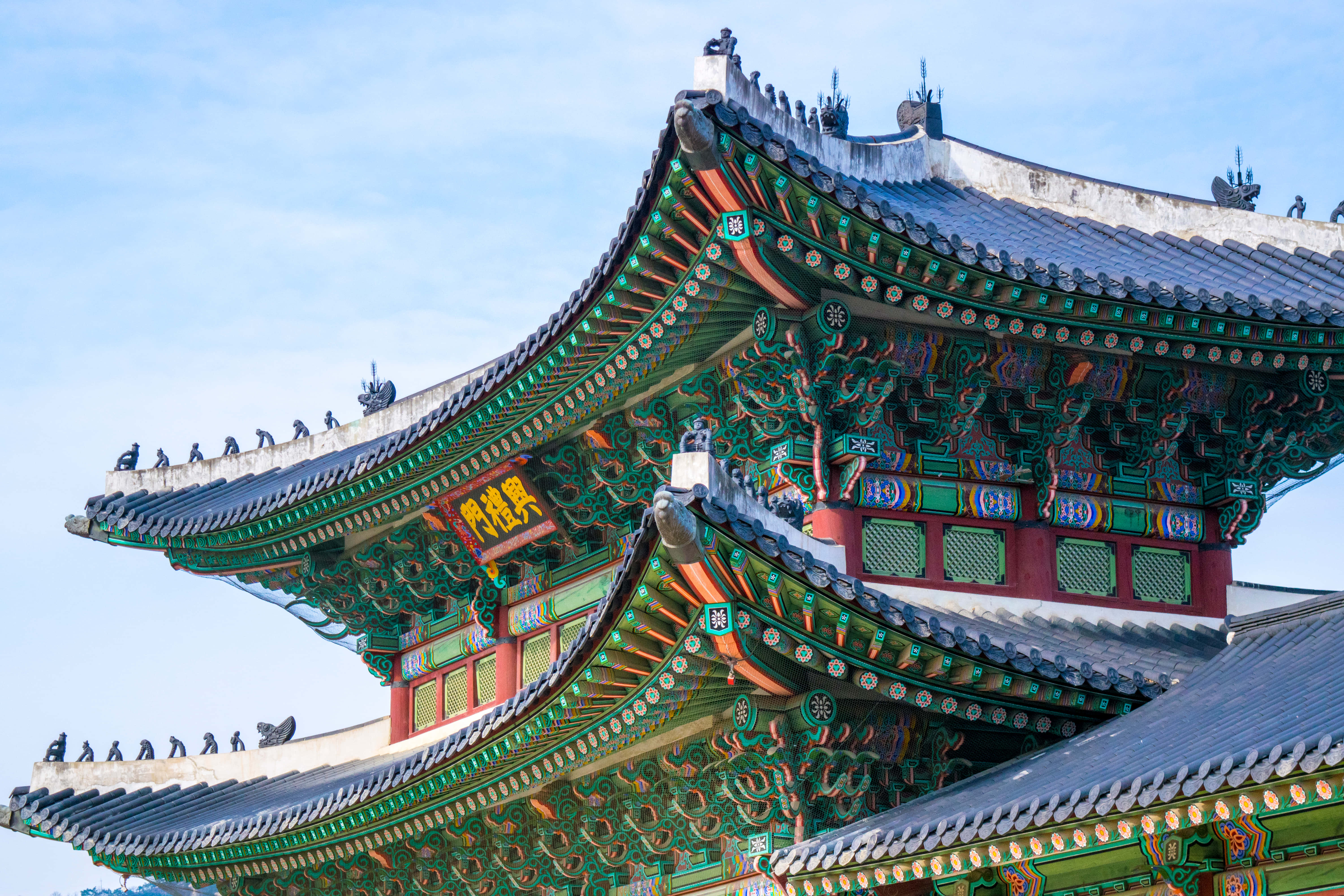 Architecture 桌布 壁紙 — 色彩鮮豔的傳統韓國寺廟屋頂，飾有華麗的綠色、紅色和金色細節，在清澈的藍天下。