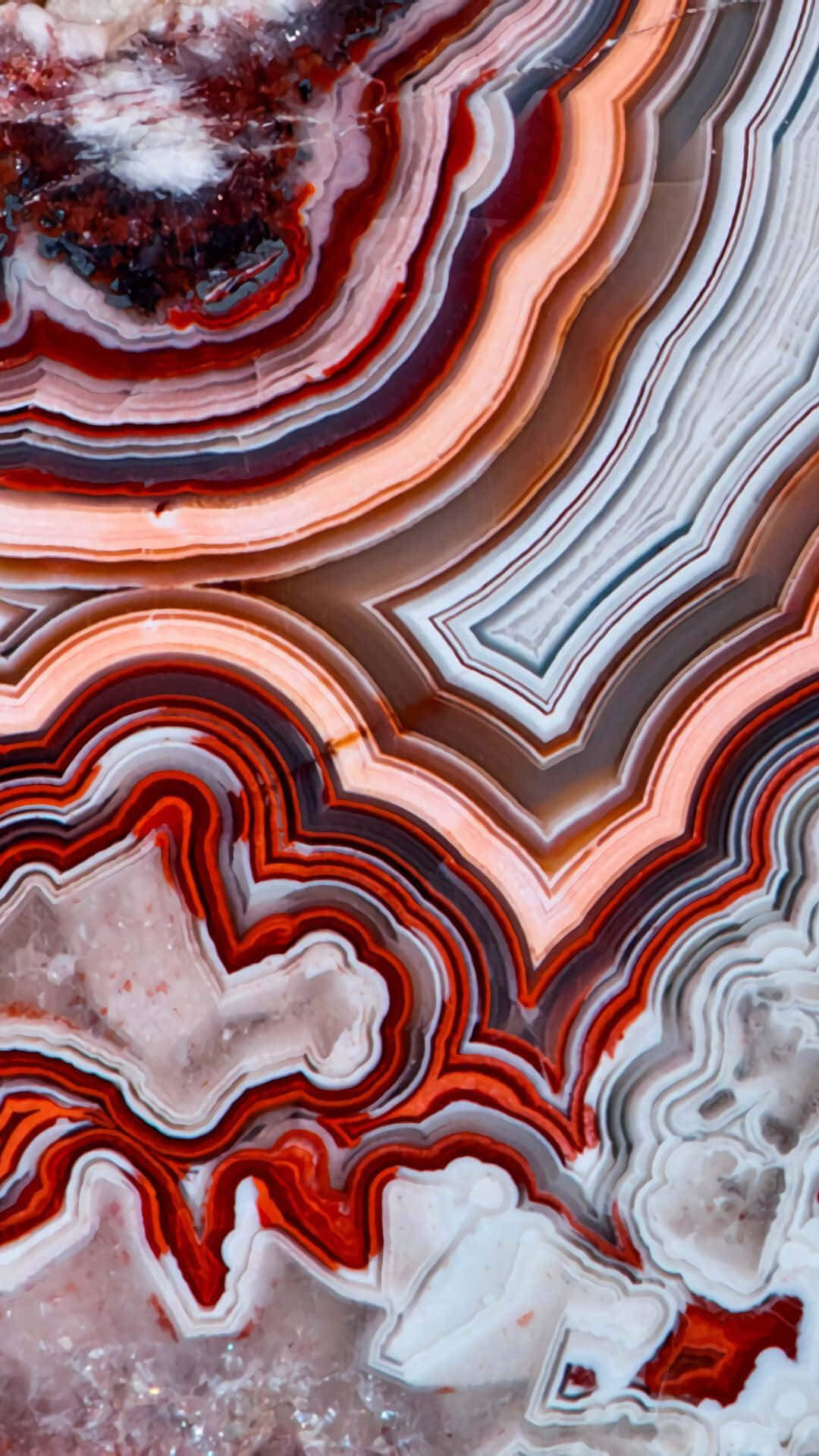 Red Marble 桌布 壁紙 — 色彩鮮豔的帶狀瑪瑙特寫，紅色、橙色、白色和灰色漩渦狀層次展現出複雜的自然圖案。