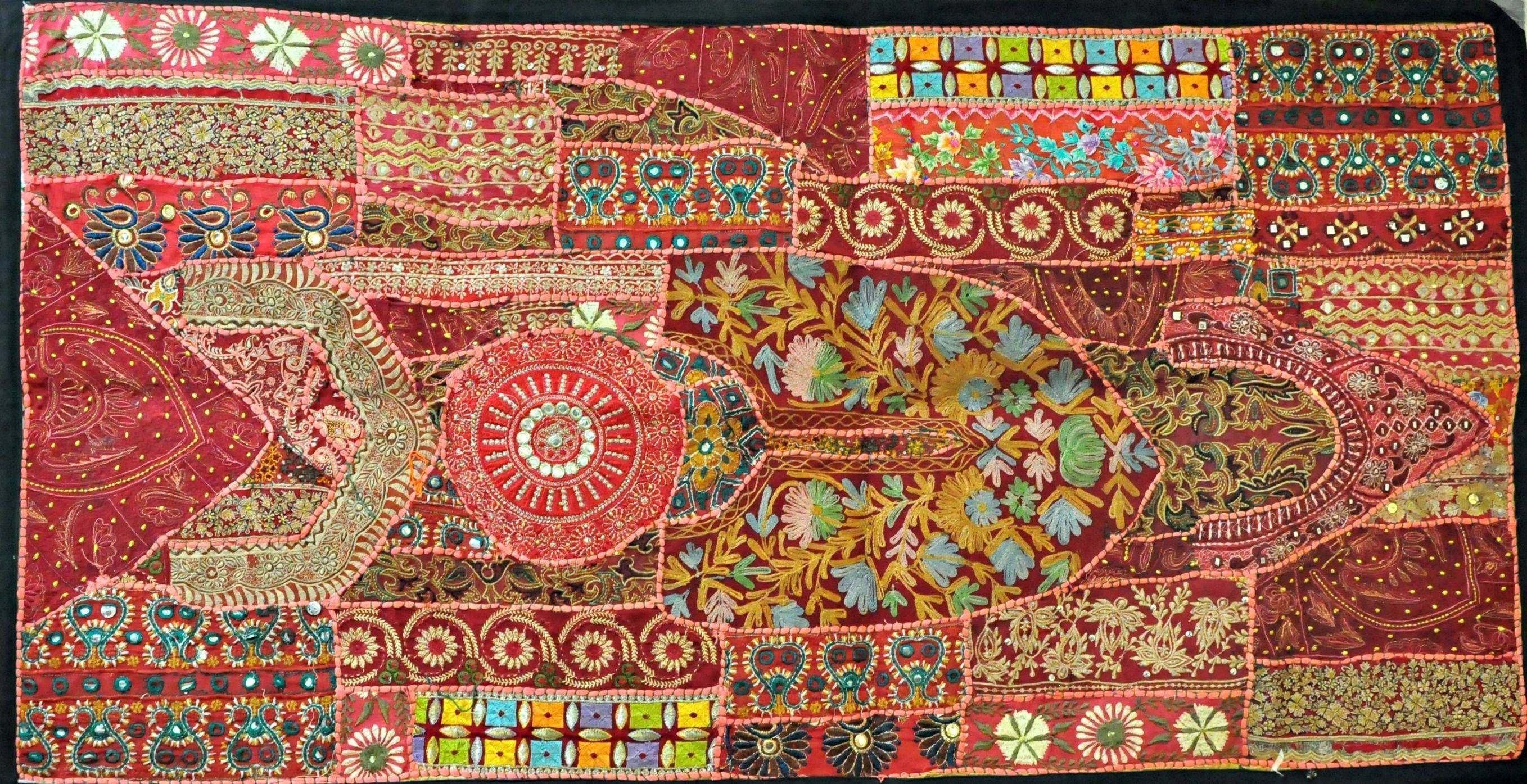 Boho 桌布 壁紙 — 色彩鮮豔的拼布紡織被，帶有精緻刺繡和幾何花卉圖案，採用豐富的紅色、金色和藍色調。