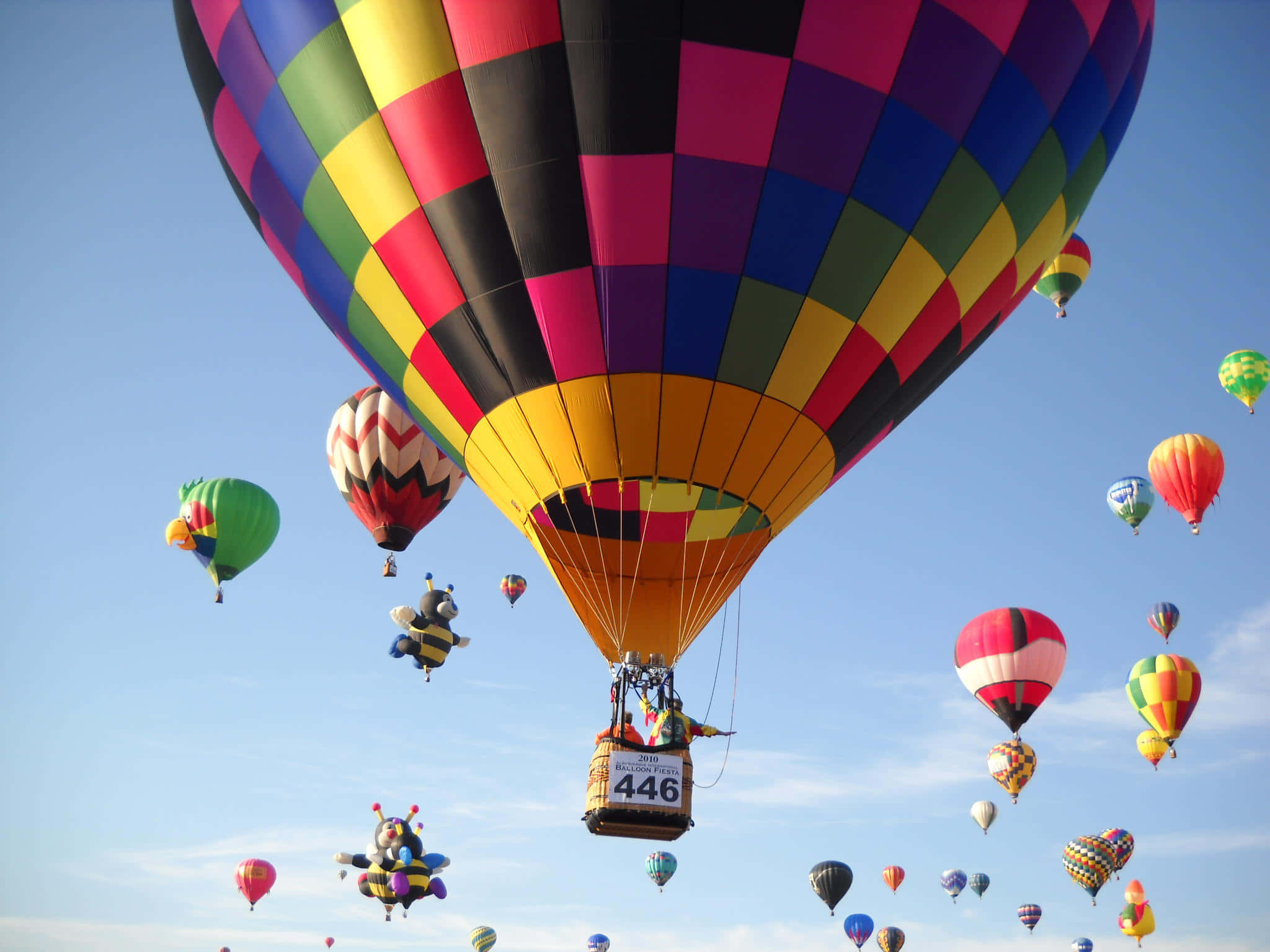 Hot Air Balloon 桌布 壁紙 — 色彩鮮豔的格子圖案熱氣球在晴朗的藍天下於節慶中翱翔。