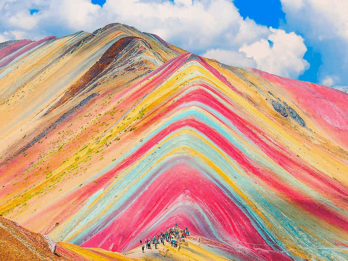 山景 桌布 壁紙 — 色彩鮮豔的條紋彩虹山，徒步旅行者在晴朗的藍天白雲下攀登。