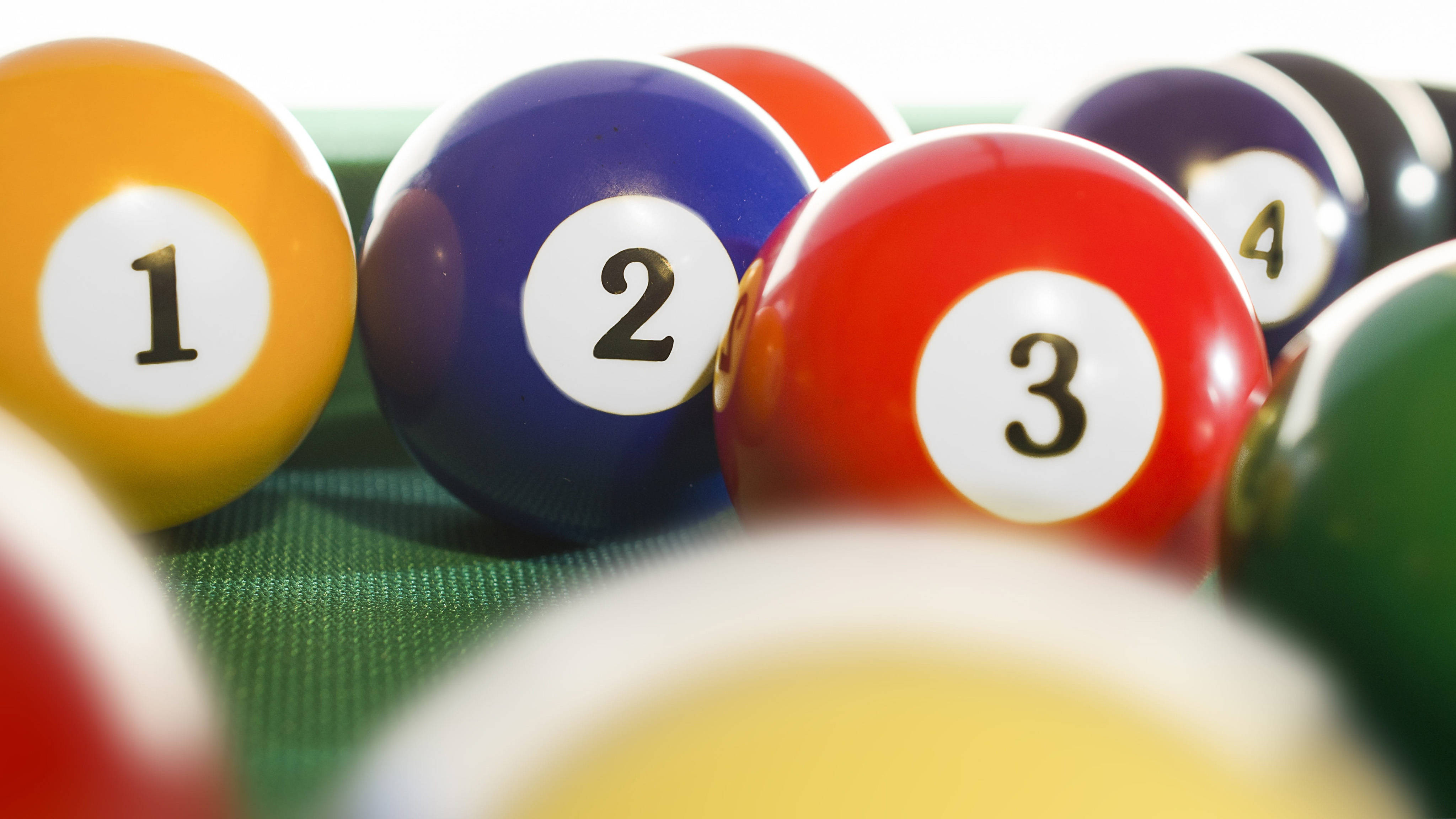 Snooker 桌布 壁紙 — 色彩鮮豔的號碼撞球放在綠色絨布上，淺景深凸顯前景的球。