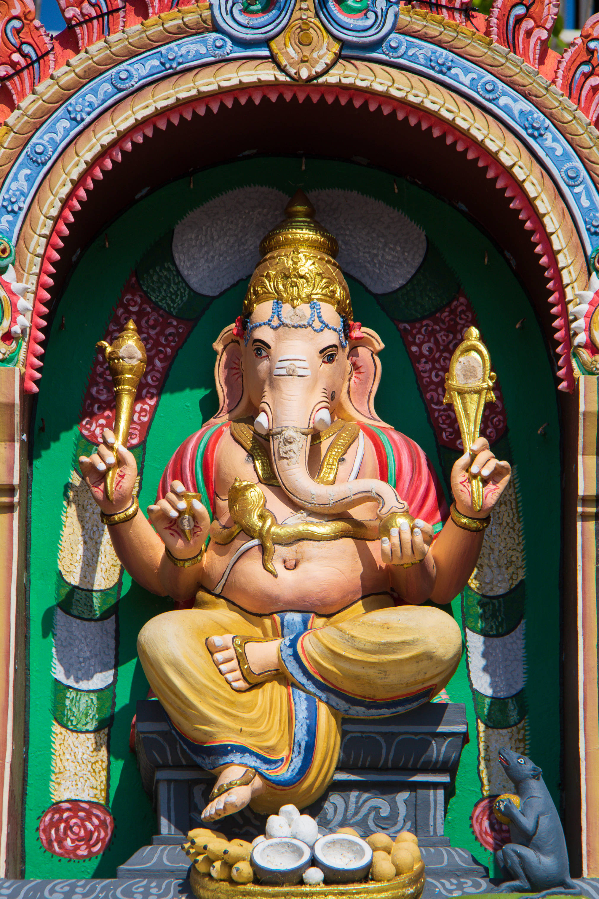 Bappa 桌布 壁紙 — 色彩鮮豔的象頭神伽內什莊嚴地坐在華麗多彩的神龕中，沐浴在明亮的日光下。