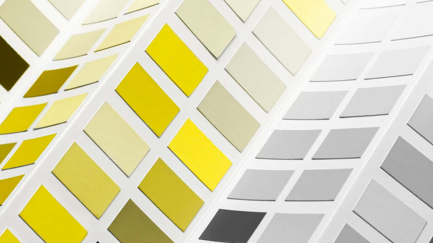 Gray And Yellow 桌布 壁紙 — 色板圖表的特寫，顯示黃色米色和灰色調的漸變，呈現幾何圖案。