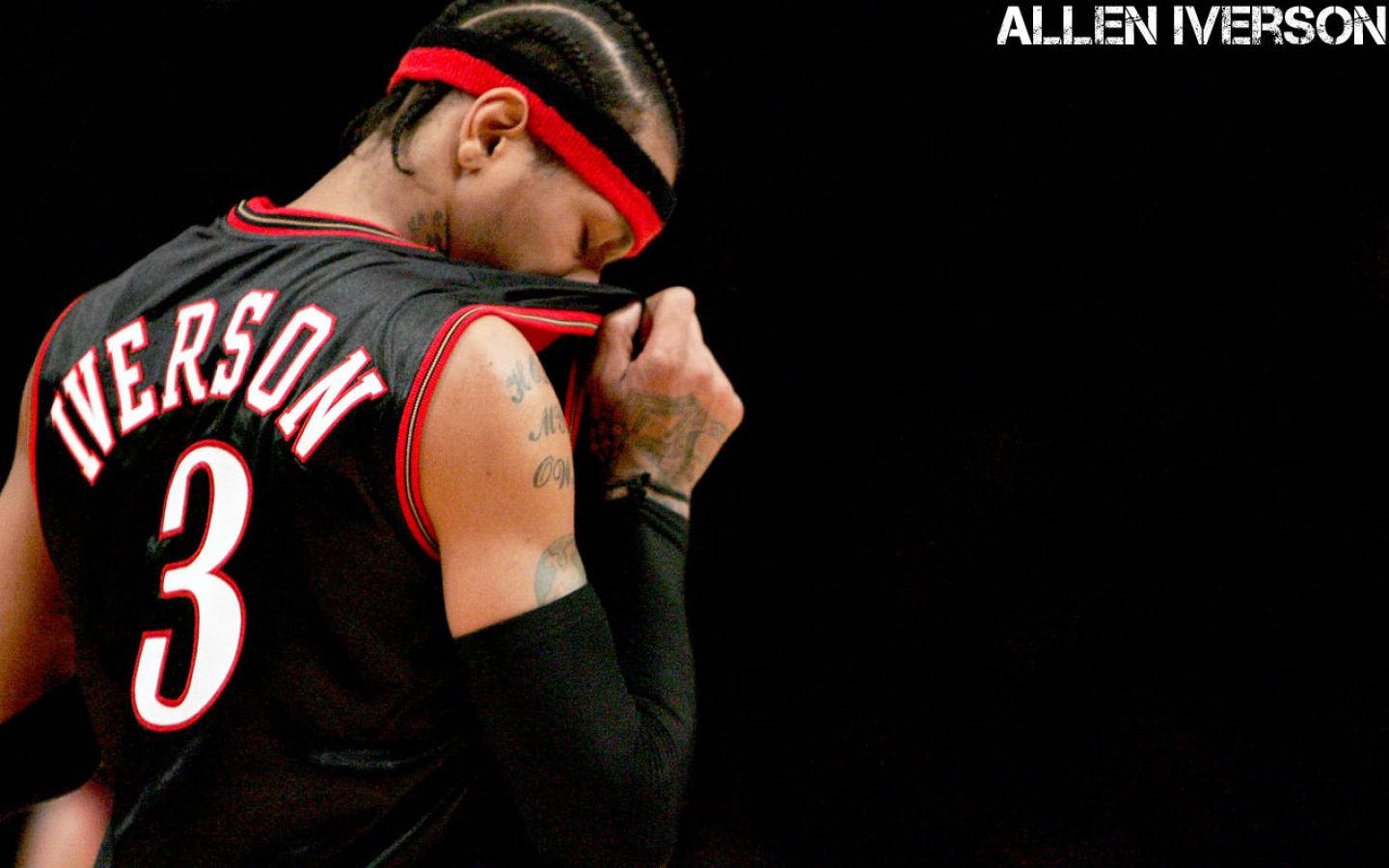 NBA 桌布 壁紙 — 艾倫·艾佛森身穿黑色3號球衣，配以紅色飾邊和頭帶，在黑暗背景下低頭沉思，展現片刻的靜默專注。