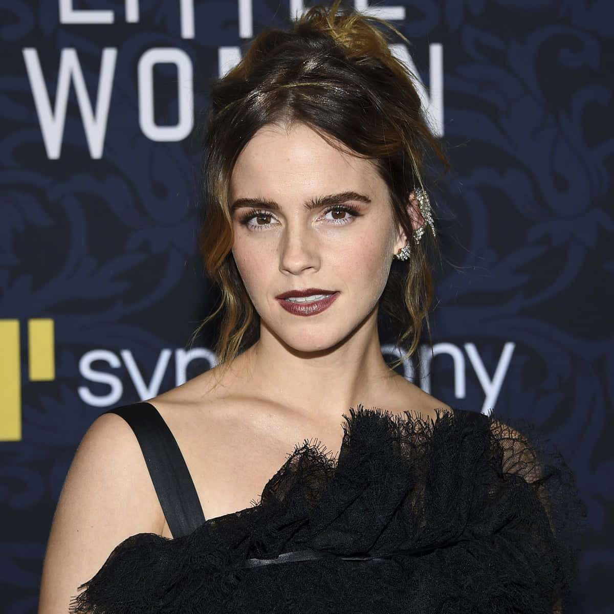 Emma Watson 桌布 壁紙 — 艾瑪華森在一個『小婦人』活動中，身穿黑色蕾絲裙，在深色圖案背景前擺姿勢。