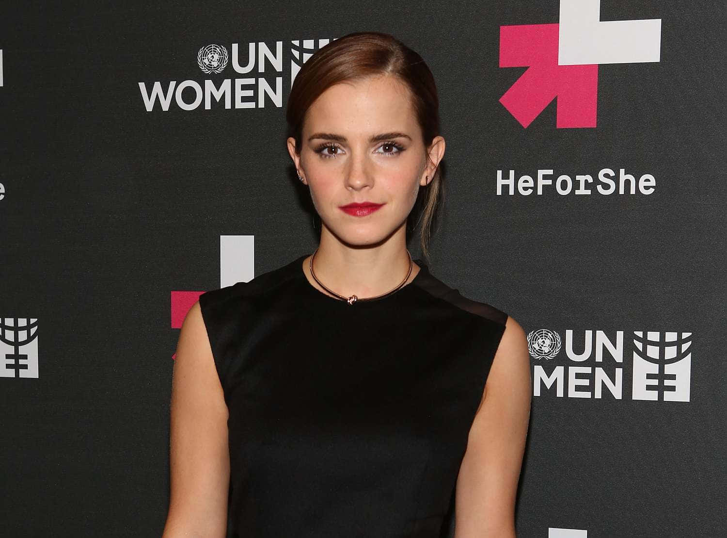 Emma Watson 桌布 壁紙 — 艾瑪華森自信地穿著黑色連衣裙，以聯合國婦女署HeForShe活動背景為襯托。