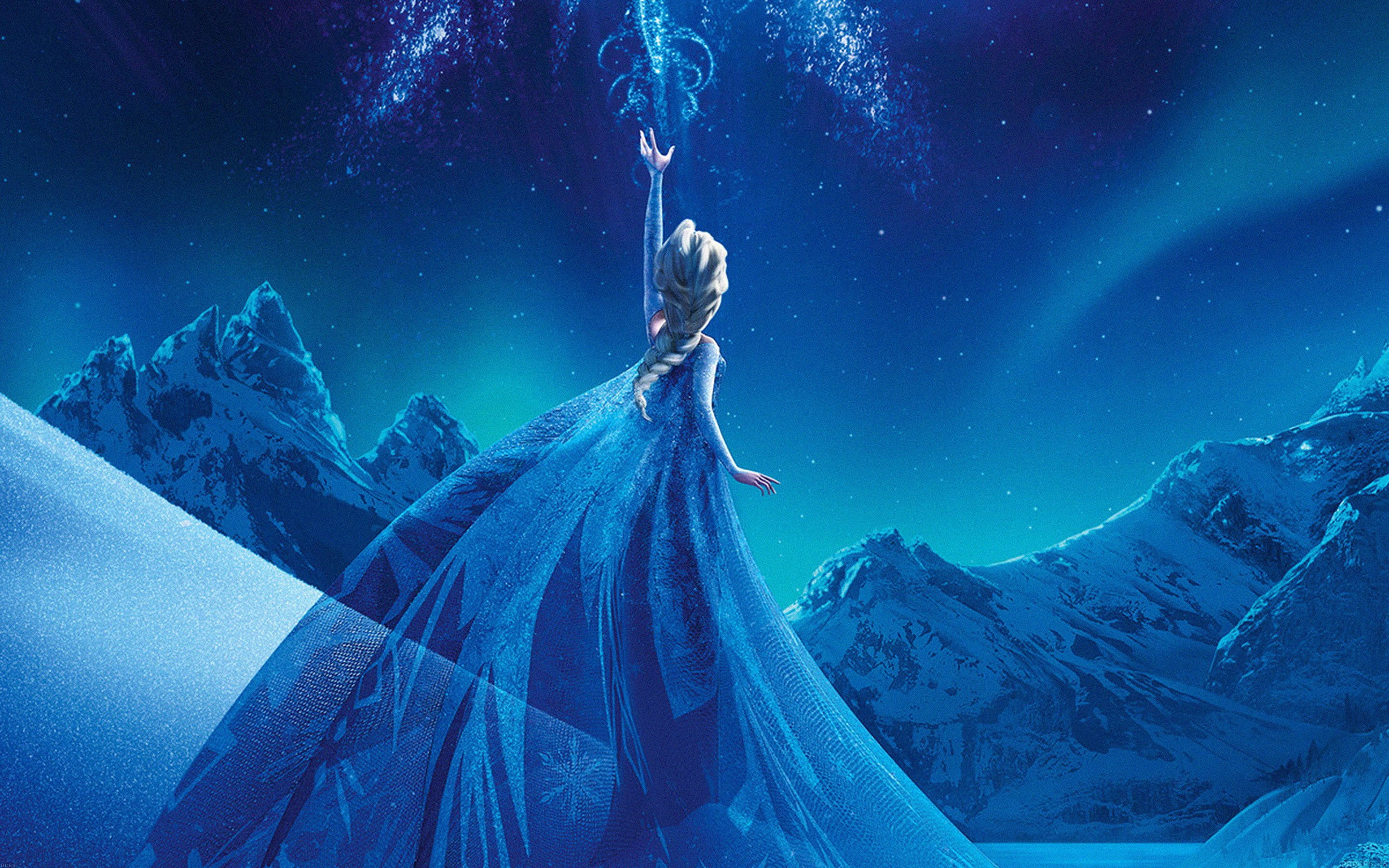 Frozen Elsa 桌布 壁紙 — 艾莎站在白雪覆蓋的山頂上，身穿飄逸的藍色長裙，雙臂高舉，魔法冰晶在她頭頂上旋轉，背景是繁星點點的夜空。