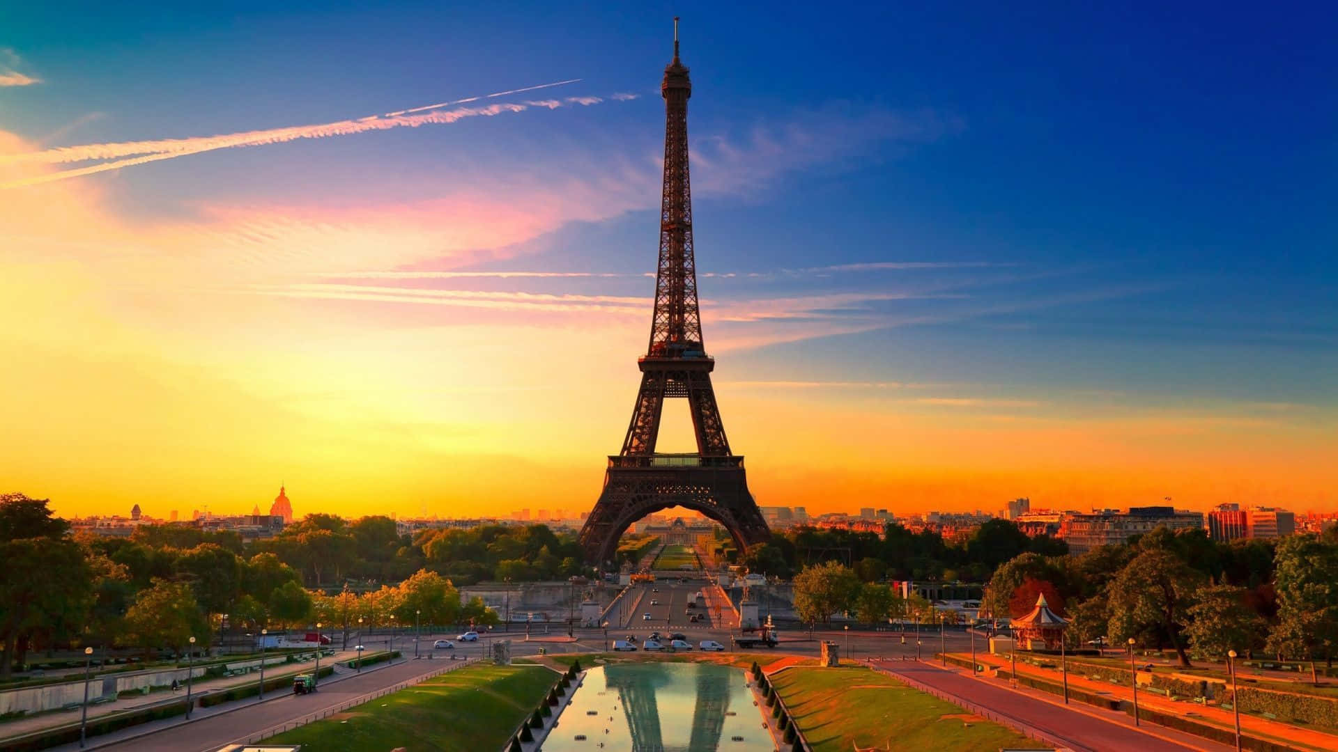 Paris Desktop 桌布 壁紙 — 艾菲爾鐵塔在 vibrant 的日落天空下高聳，金色的光芒反射在下面的塞納河上。