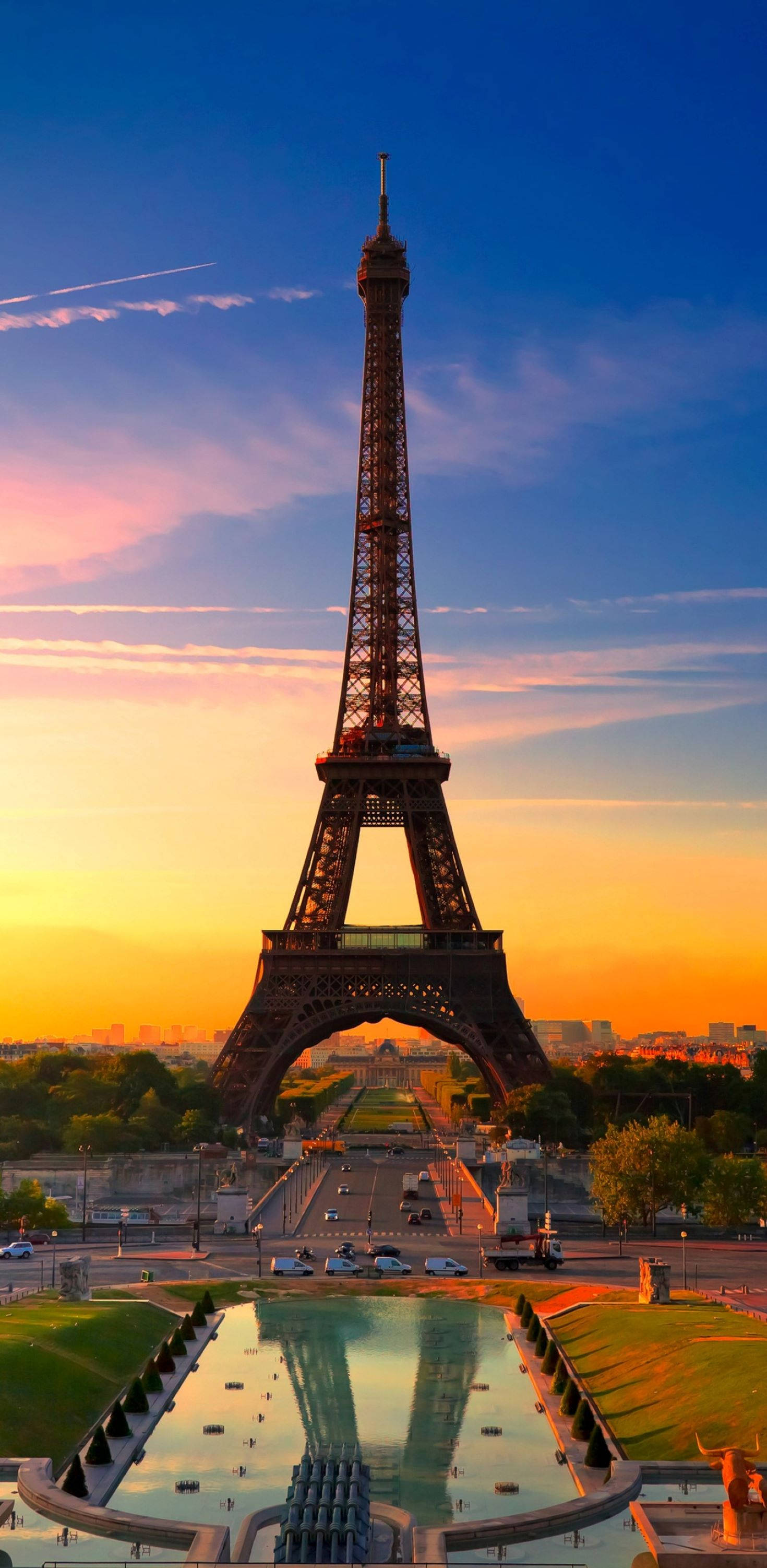France 桌布 壁紙 — 艾菲爾鐵塔在充滿活力的日落天空下高聳，金色的光線反射在下方如鏡的水面上。