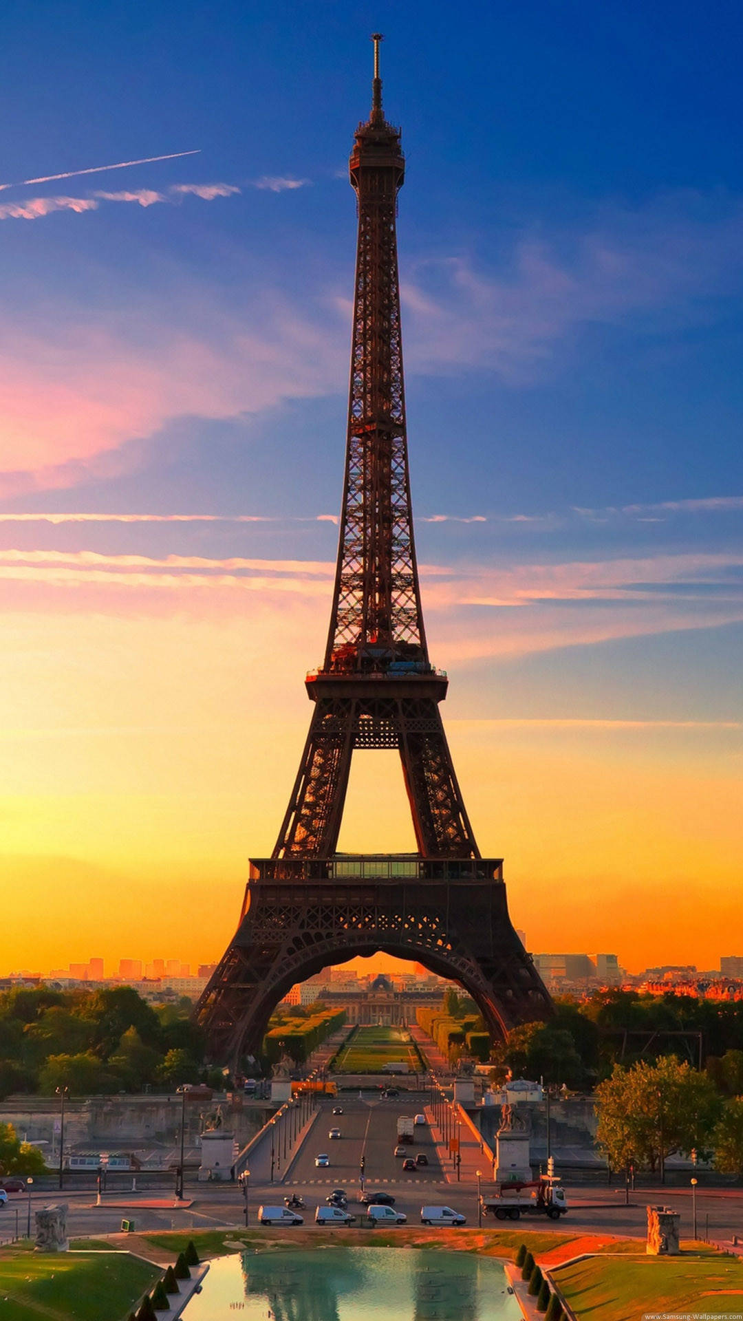 full HD tablet 桌布 壁紙 — 艾菲爾鐵塔在充滿活力的日落天空下高聳，金色光芒照亮其鐵結構並反射在下面的水面上。