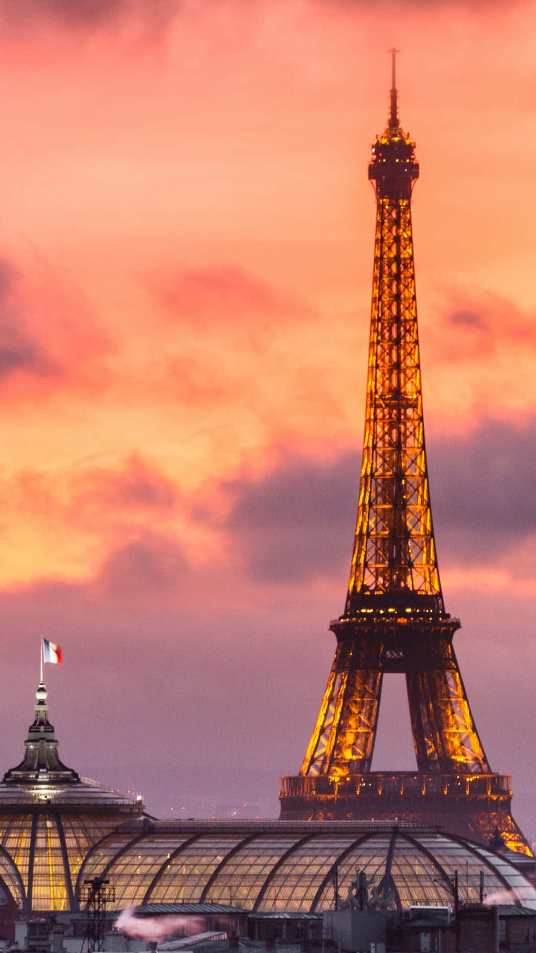 Eiffel Tower 桌布 壁紙 — 艾菲爾鐵塔在充滿活力的粉紅色和橙色日落天空與柔軟的雲朵中溫暖地發光。