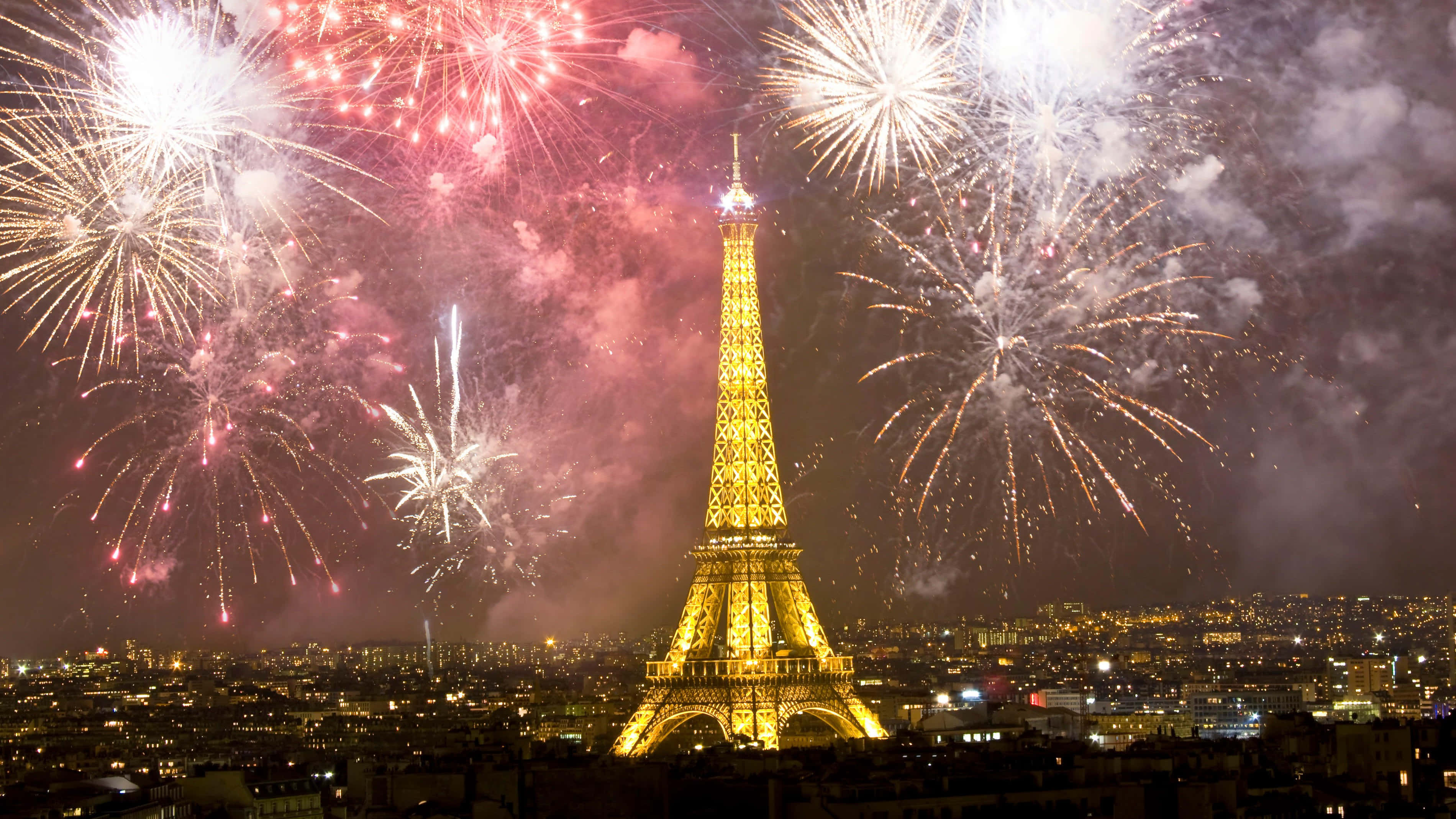 Eiffel Tower 桌布 壁紙 — 艾菲爾鐵塔在巴黎上空綻放鮮豔紅白煙火的夜空襯托下閃耀金光。