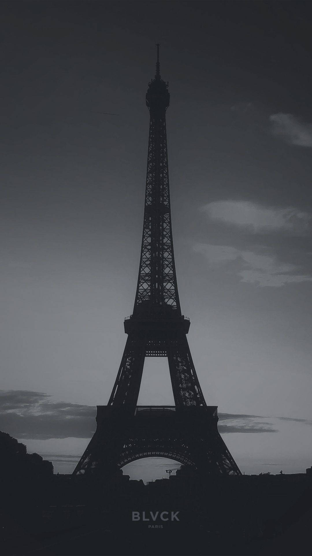 Blvck Paris 桌布 壁紙 — 艾菲爾鐵塔在帶有柔和雲朵的陰鬱暮色天空中，呈現出鮮明的剪影。