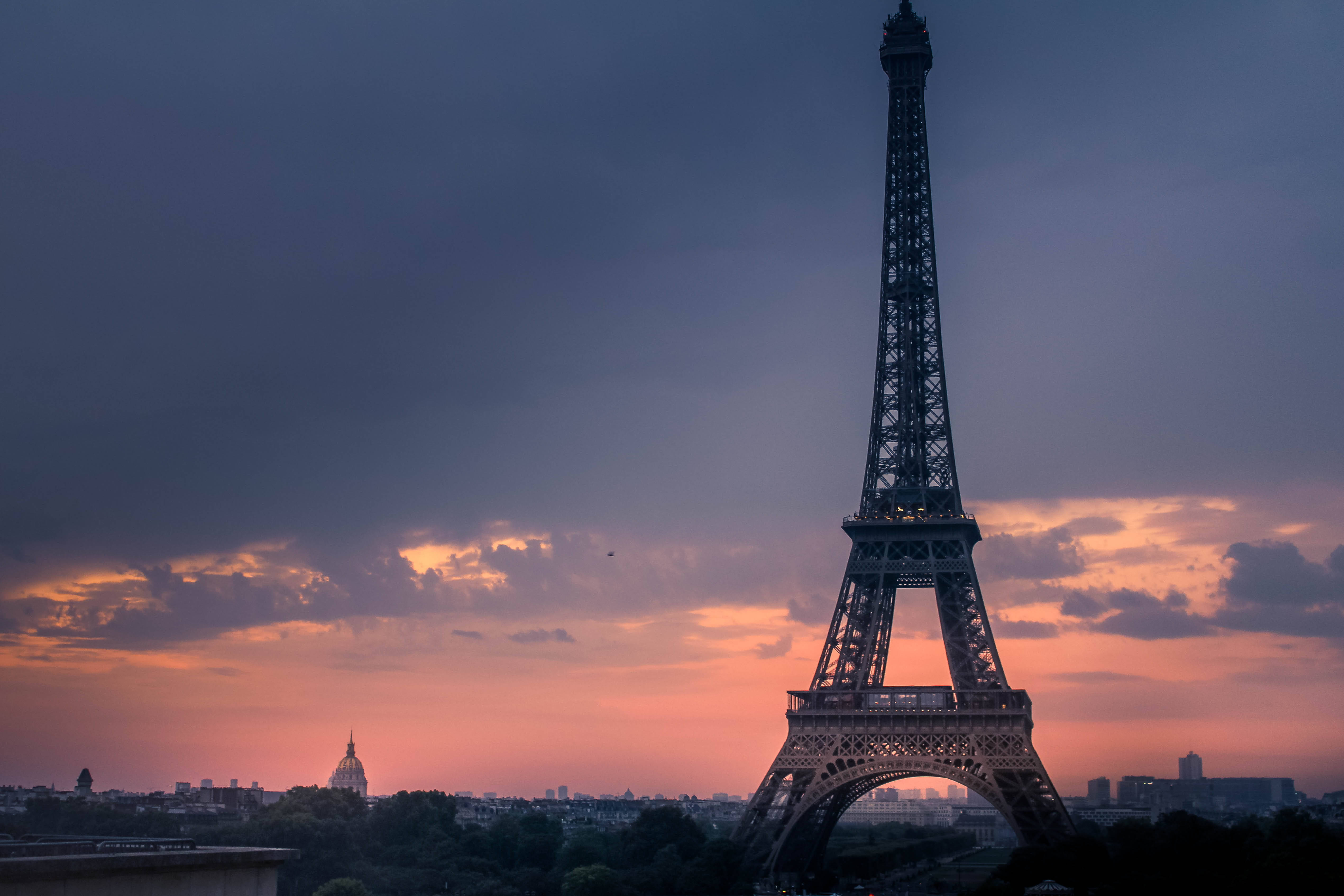 Pink Eiffel Tower 桌布 壁紙 — 艾菲爾鐵塔在戲劇性的暮色天空中呈現剪影，天空中有火紅的橙色雲彩和深紫色調。