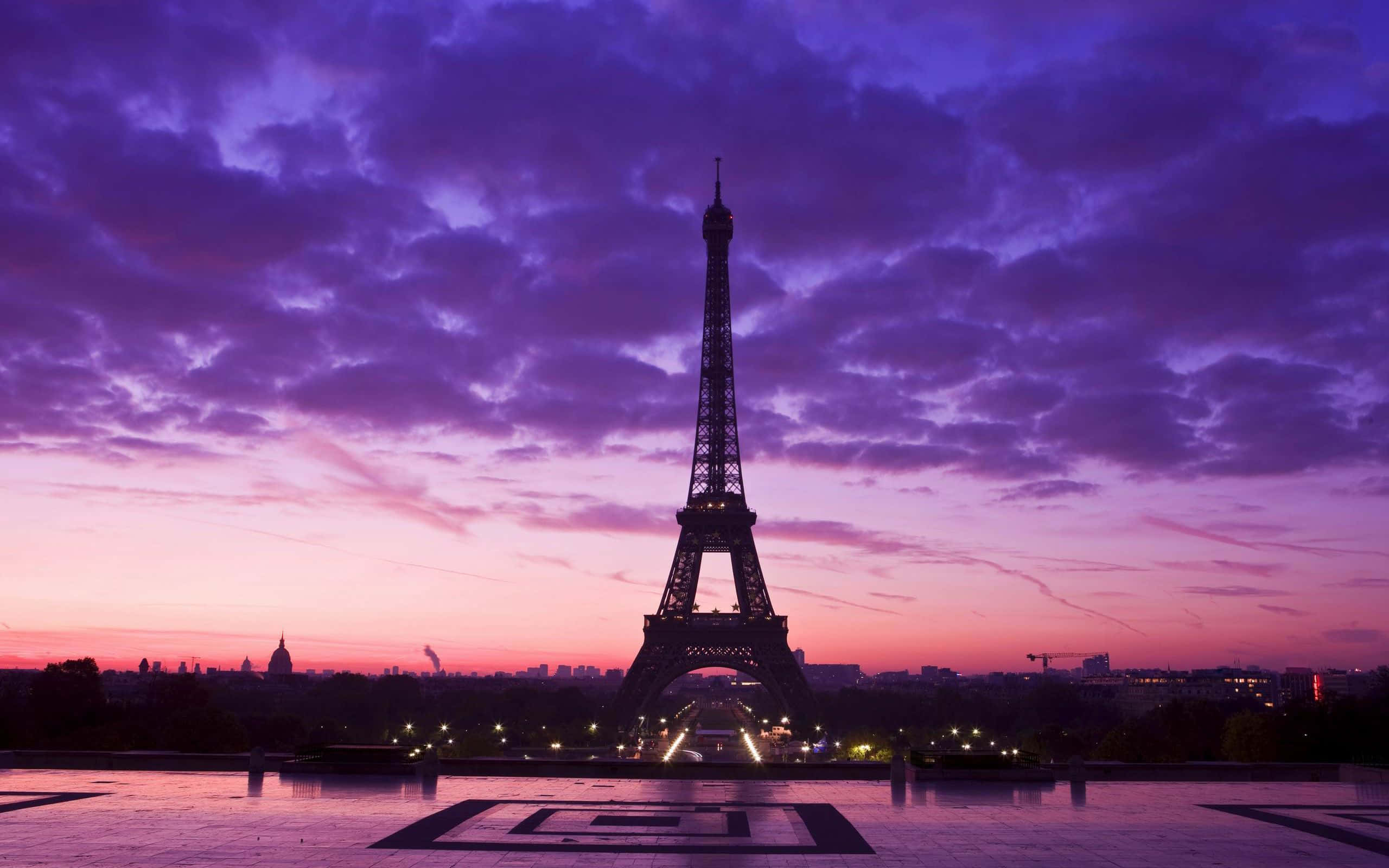 Paris Desktop 桌布 壁紙 — 艾菲爾鐵塔在戲劇性的紫色和粉紅色暮色天空下呈現剪影，下方城市燈光閃爍。