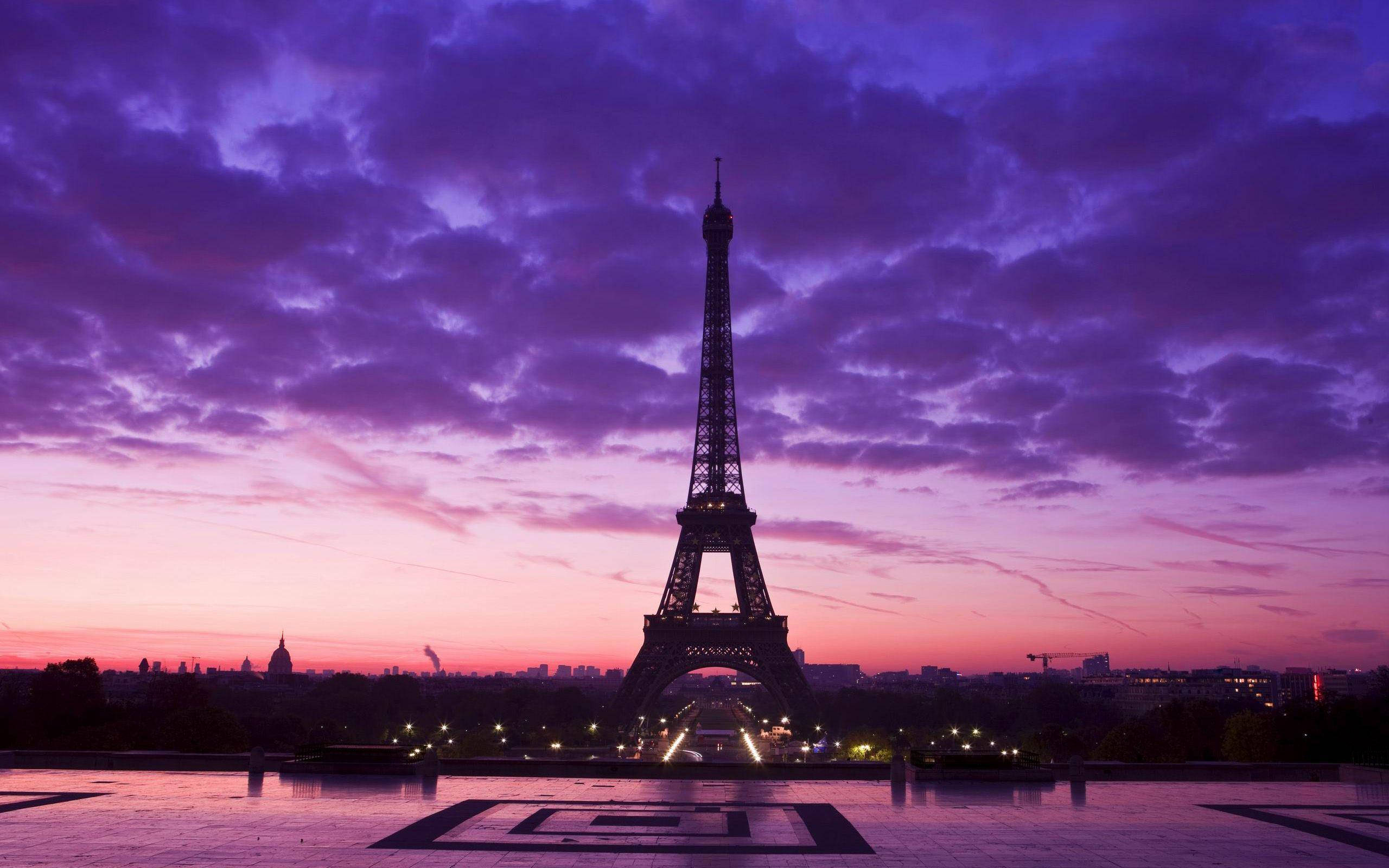 Paris Eiffel Tower 桌布 壁紙 — 艾菲爾鐵塔在戲劇性的紫色和粉紅色暮色天空下呈現剪影，下方城市燈光閃爍。