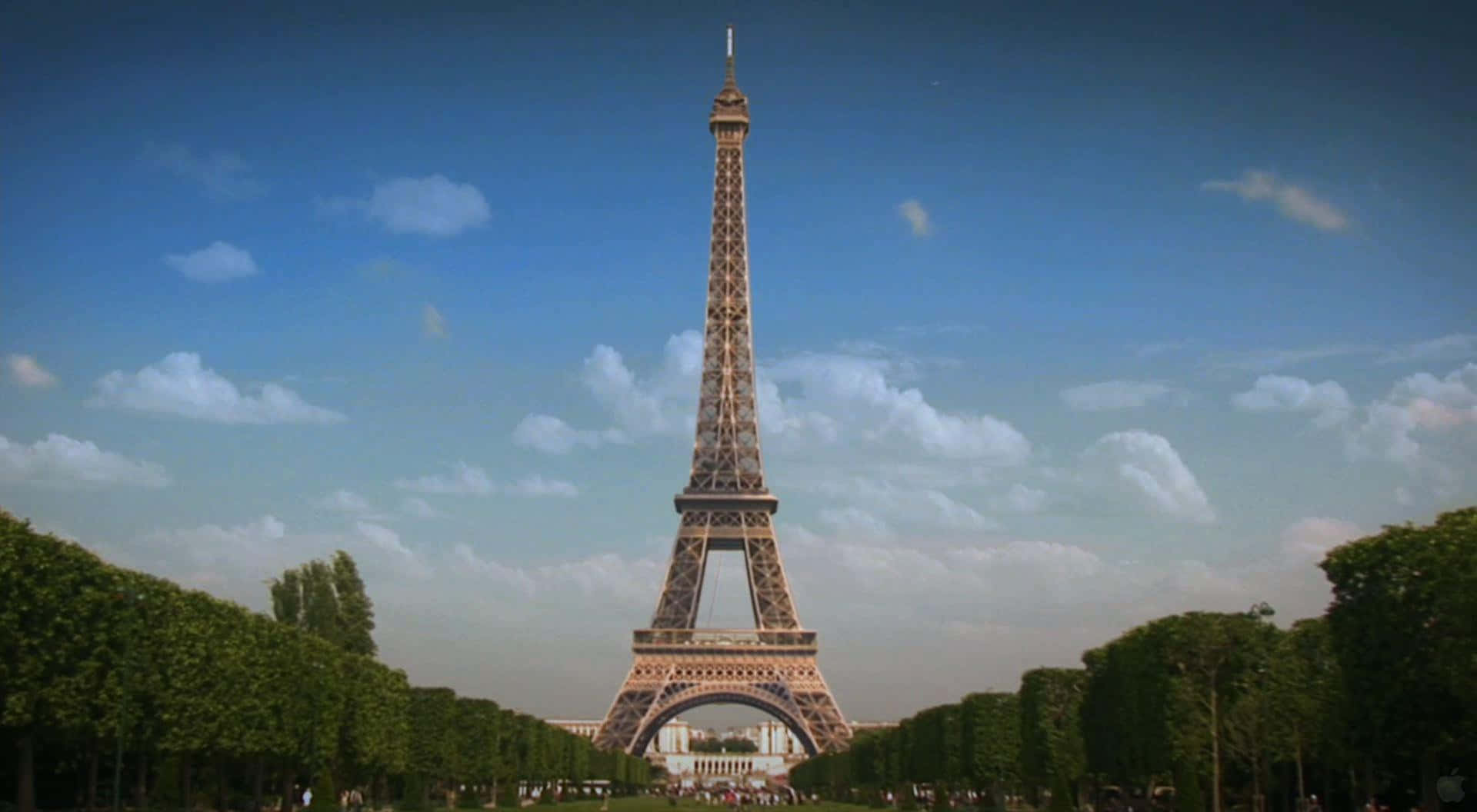 Eiffel Tower 桌布 壁紙 — 艾菲爾鐵塔在明亮的藍天和白雲映襯下高聳入雲，兩旁對稱排列著茂密的綠樹。