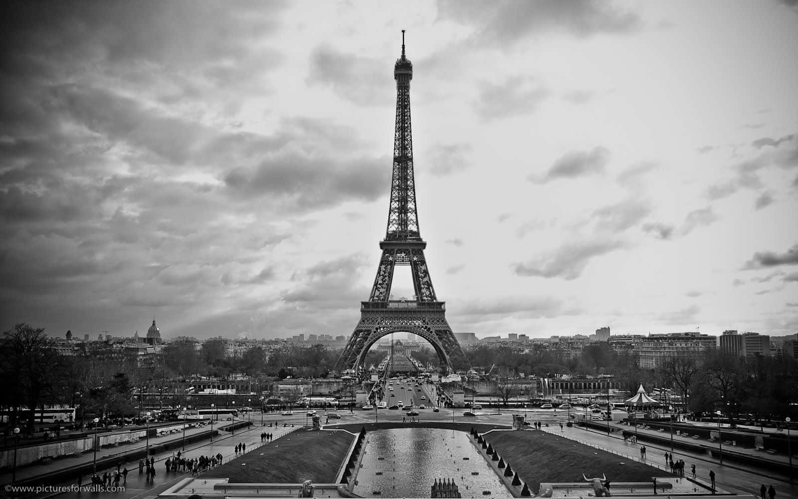 Paris Desktop 桌布 壁紙 — 艾菲爾鐵塔在陰雲密佈的天空下高聳入雲的單色景觀，下方是城市景觀和小徑。