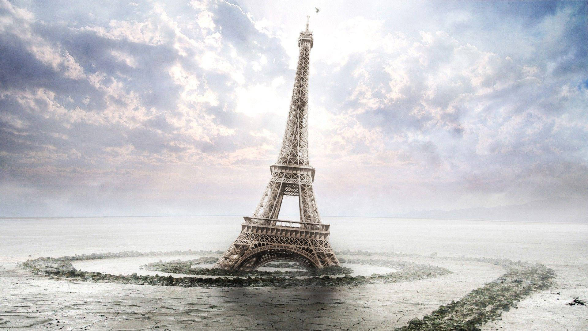 Eiffel Tower 桌布 壁紙 — 艾菲爾鐵塔獨自矗立在廣闊的冰凍海洋中，天空陰雲密布，氣氛戲劇化。