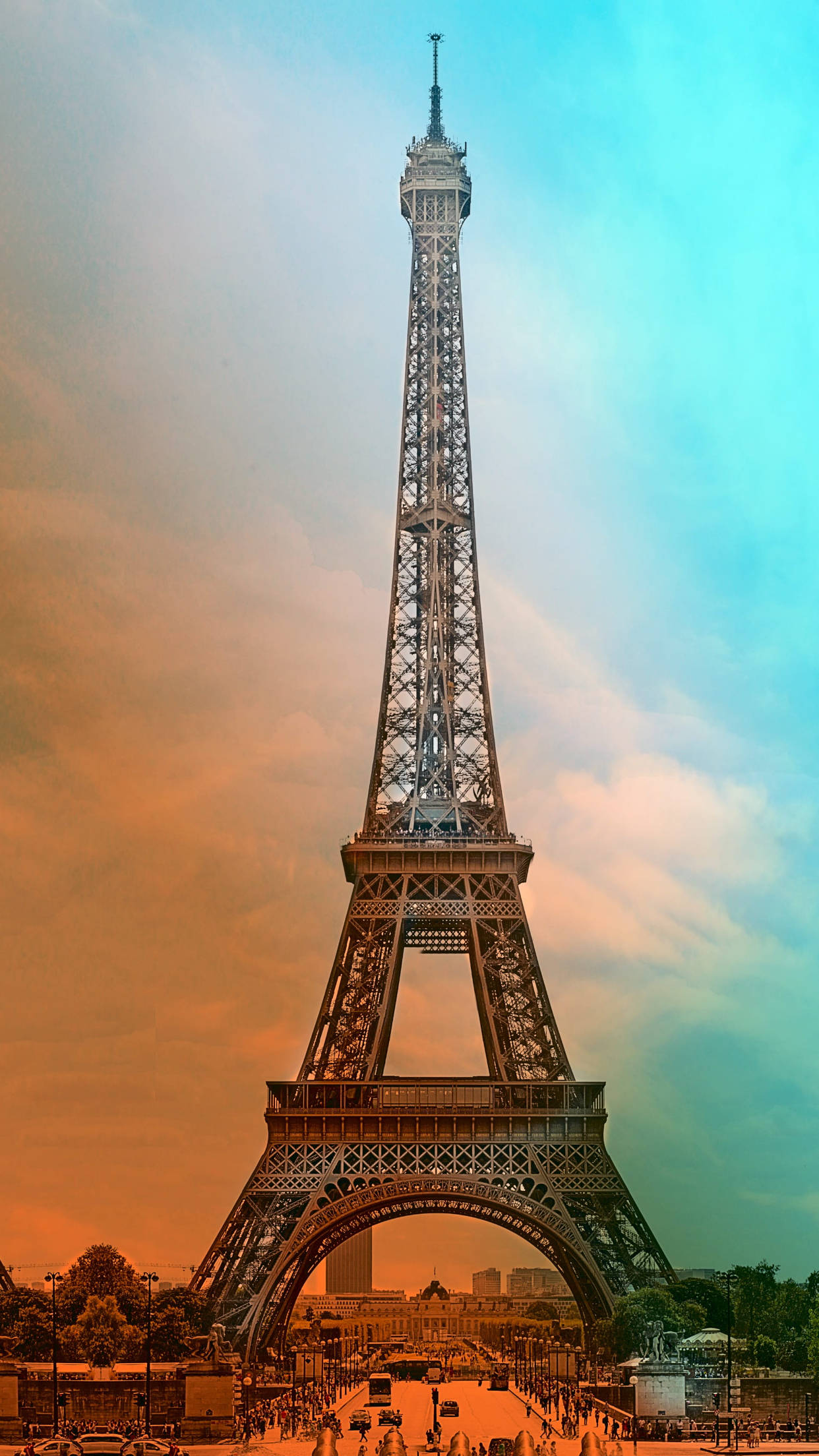 France 桌布 壁紙 — 艾菲爾鐵塔高聳入雲，映襯著暮色中融合了火熱橙色和冷色調藍綠色的超現實天空。