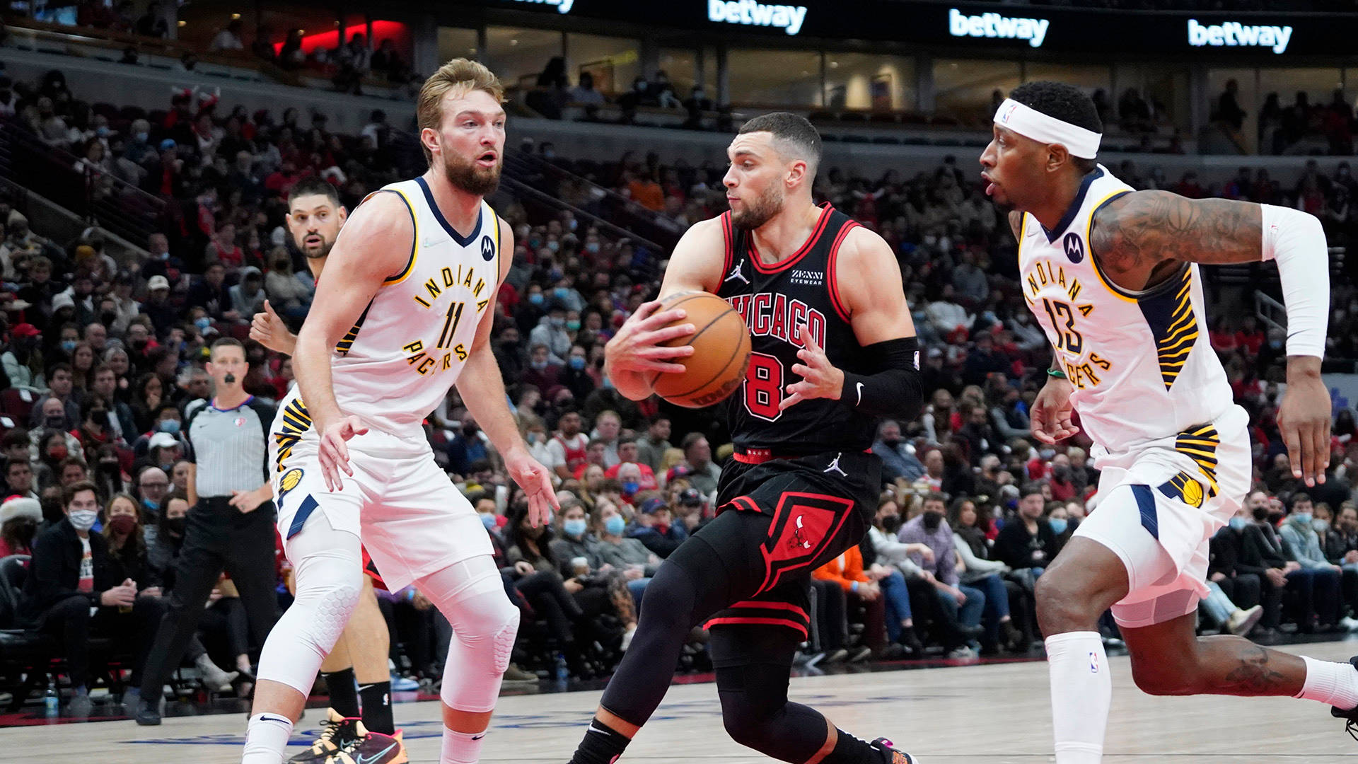 Zach 桌布 壁紙 — 芝加哥公牛隊球員在滿座的NBA比賽中運球，同時被兩名印第安納溜馬隊防守球員緊密防守。