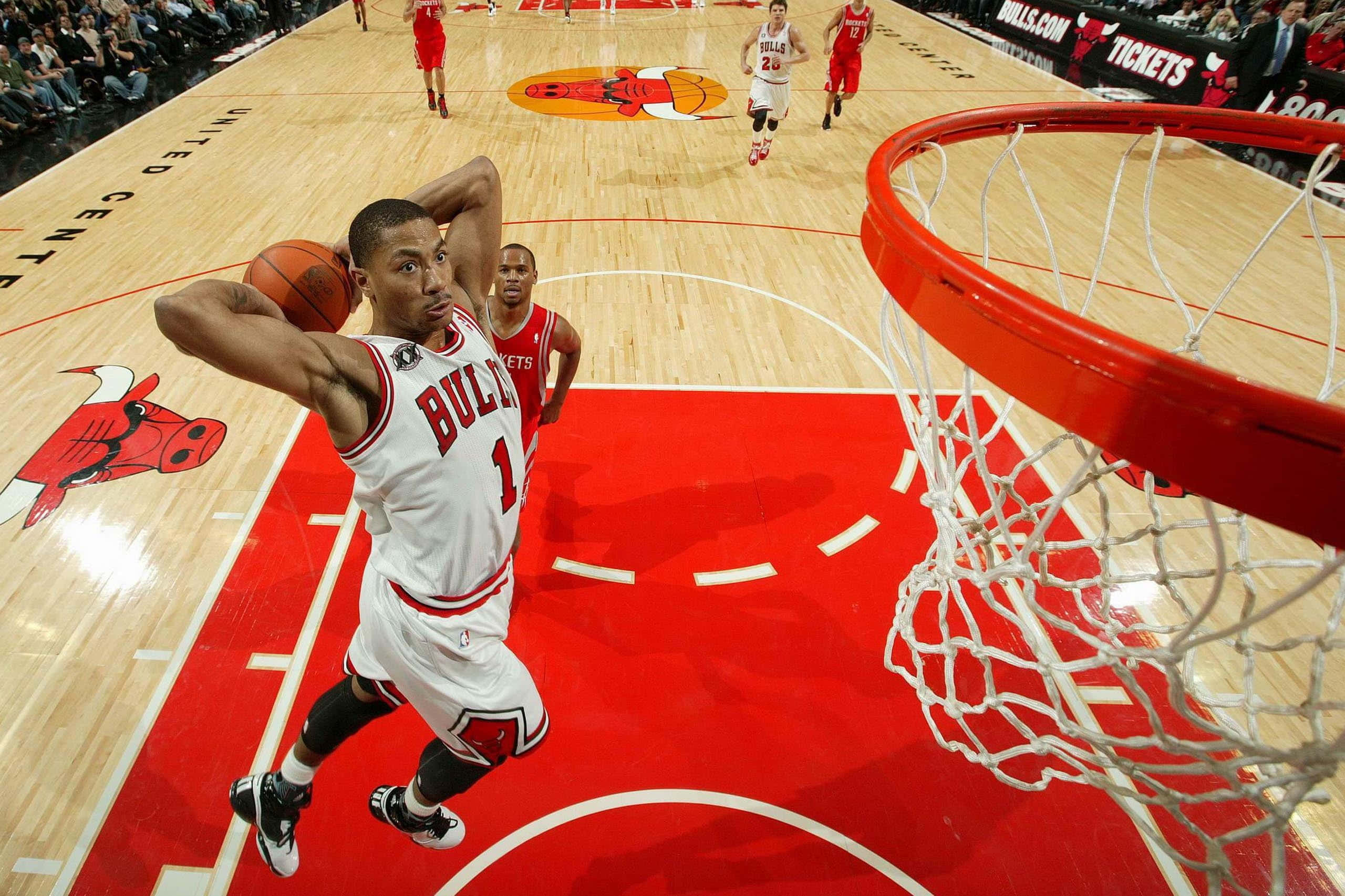 NBA 桌布 壁紙 — 芝加哥公牛隊球員在空中大力灌籃，專注力極強，隊友和對手在場上觀看。