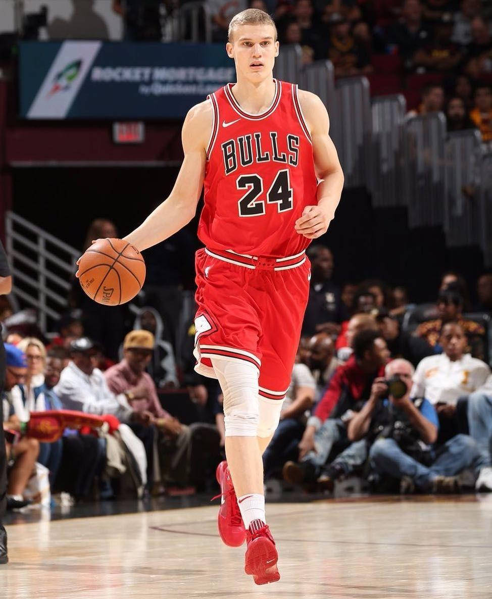 NBA iPhone 桌布 壁紙 — 芝加哥公牛隊身穿紅色24號球衣的籃球運動員在明亮的場館燈光下，於激烈的比賽中運球前進。