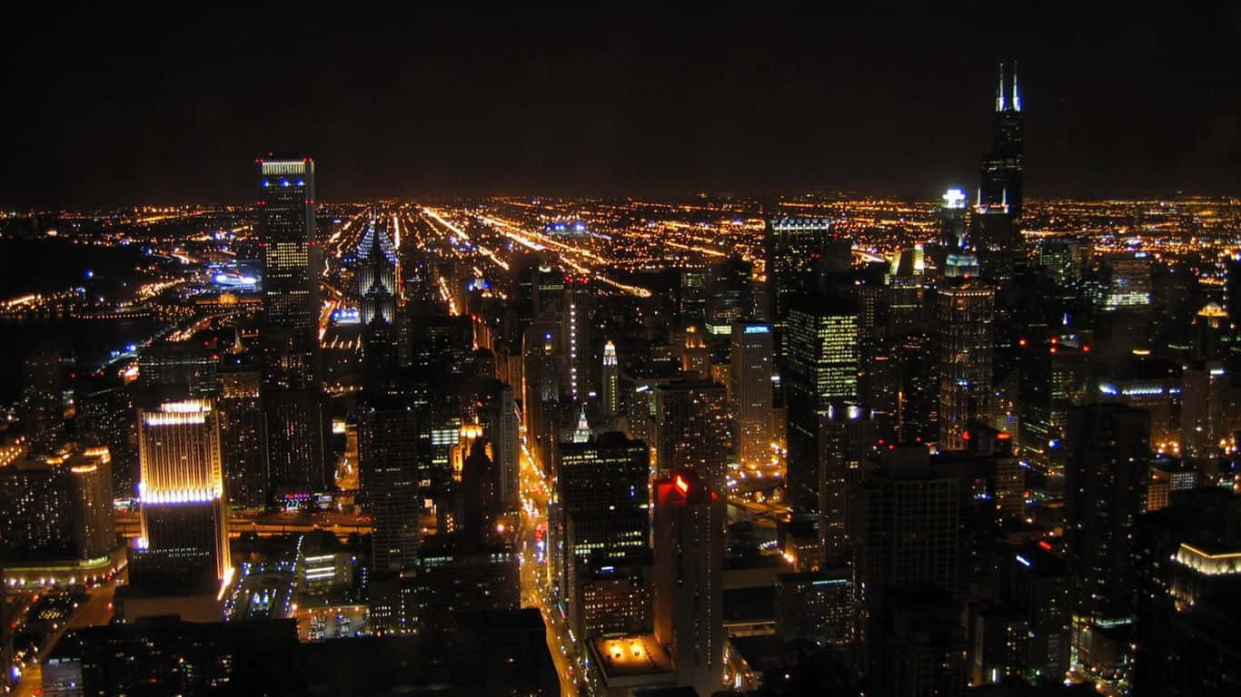 1366x768 Empire State Building 桌布 壁紙 — 芝加哥天際線的夜間航拍景觀，閃爍的摩天大樓和燈火通明的街道延伸至遠方。