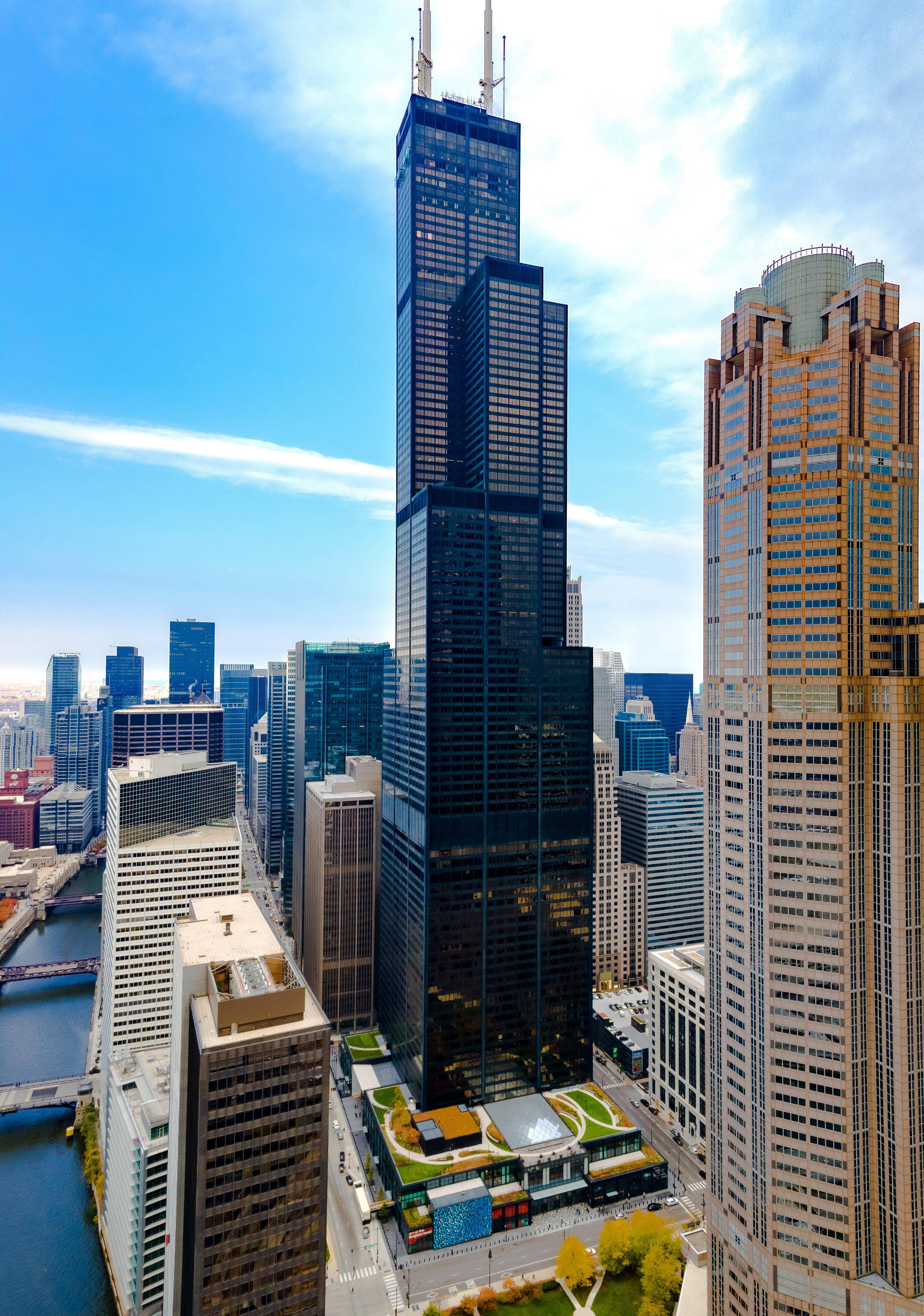 Buildings 桌布 壁紙 — 芝加哥威利斯大厦的空中景觀，刺穿明亮的藍天，下方是密集的現代摩天大樓群和蜿蜒的河流。