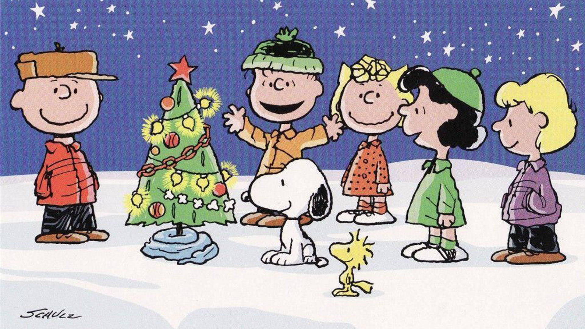 Snoopy Christmas 桌布 壁紙 — 花生漫畫角色們聚集在裝飾好的聖誕樹周圍，背景是繁星點點的雪夜天空。