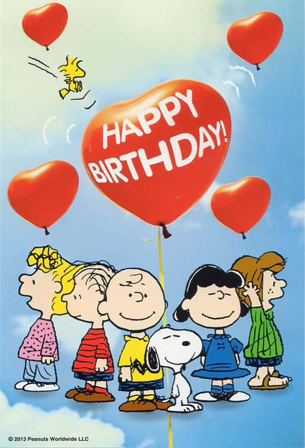 Charlie Brown Birthday 桌布 壁紙 — 花生漫畫角色在佈滿紅色心形氣球的天空下微笑，其中一個巨型氣球寫著happy birthday