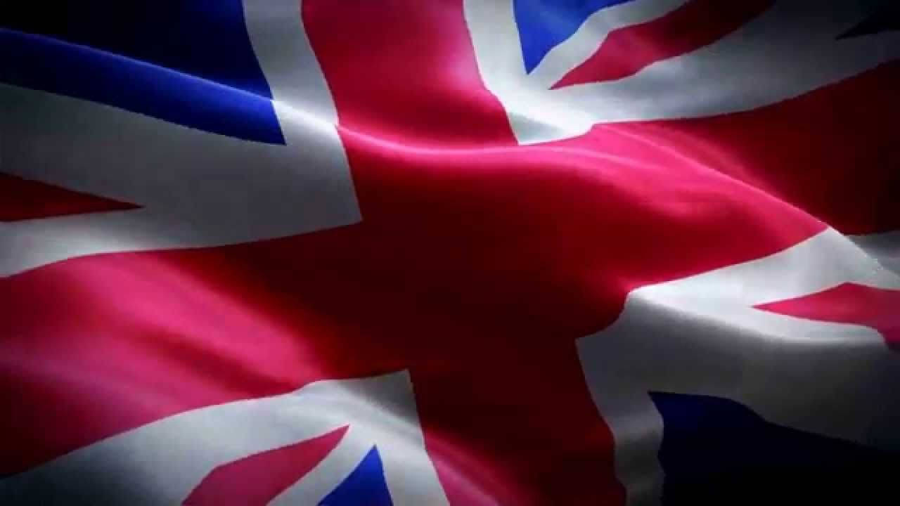 United Kingdom Flag 桌布 壁紙 — 英國國旗在戲劇性燈光下以豐富的紅、藍、白色動態飄揚的特寫。