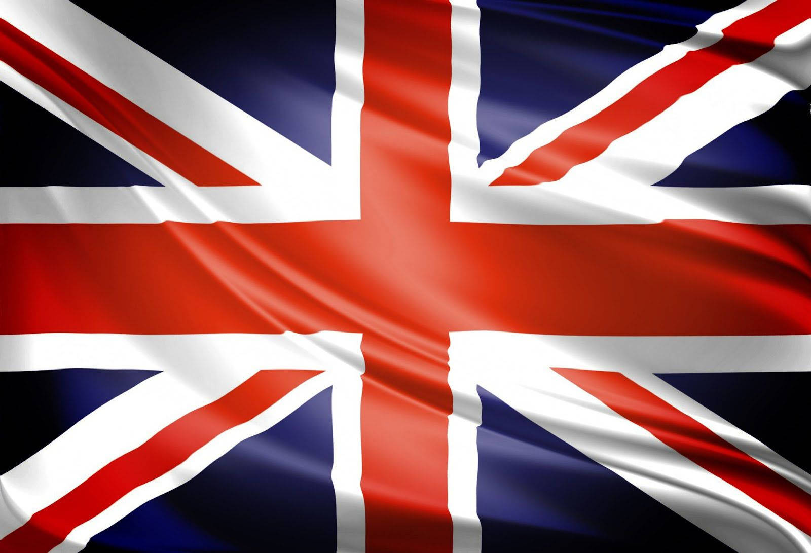 United Kingdom Flag 桌布 壁紙 — 英國國旗在明亮的日光下以豐富的紅色、白色和深藍色動態飄揚。