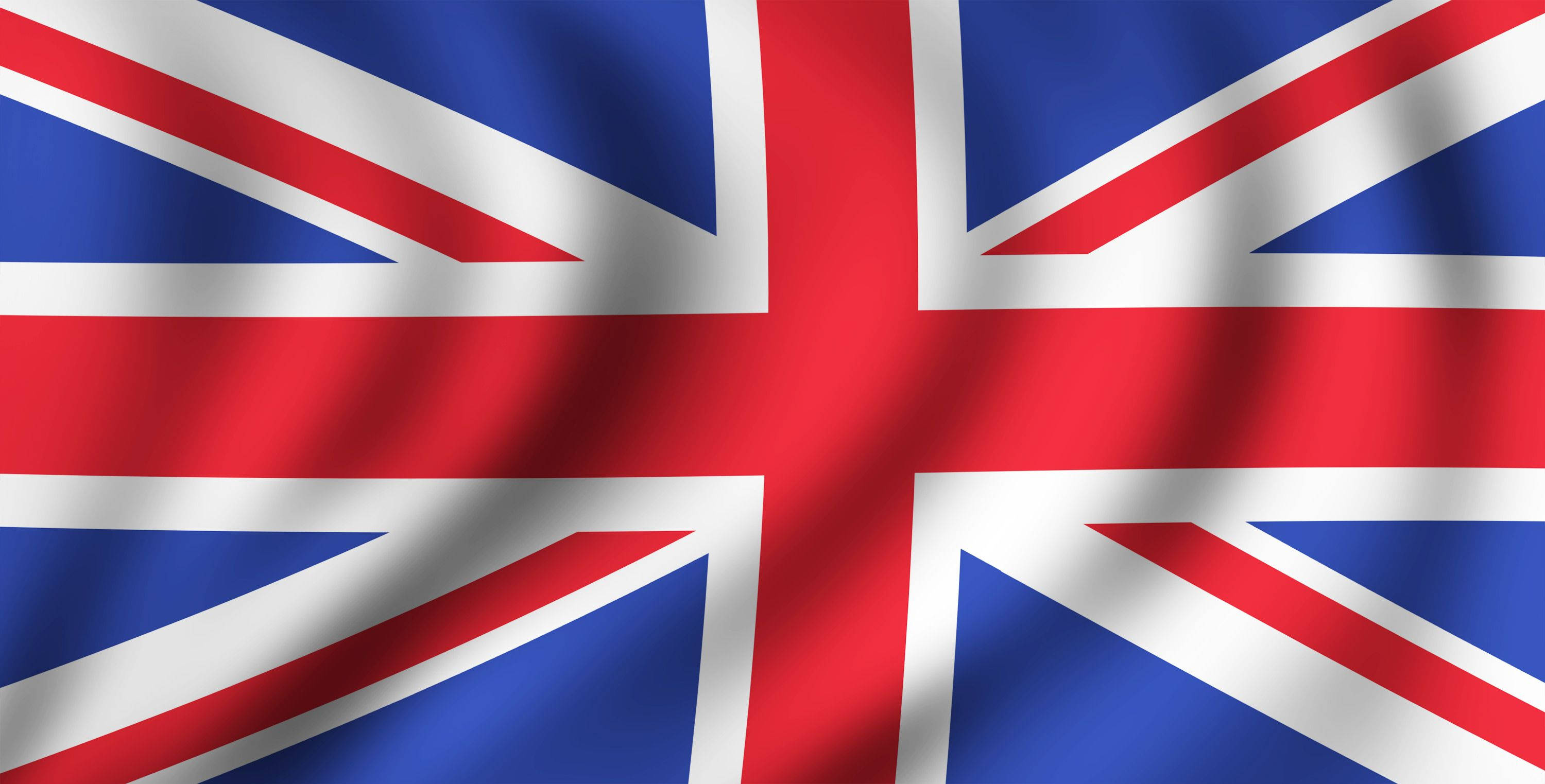 United Kingdom Flag 桌布 壁紙 — 英國國旗在明亮的日光下以豐富的紅、藍、白色動態飄揚。