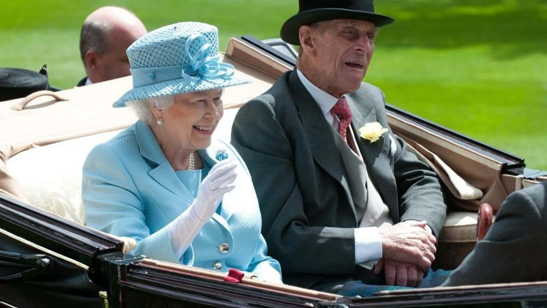 Queen Elizabeth 桌布 壁紙 — 英國女王伊莉莎白二世與菲利普親王在陽光明媚的敞篷馬車上微笑揮手，背景是充滿活力的綠色草坪。