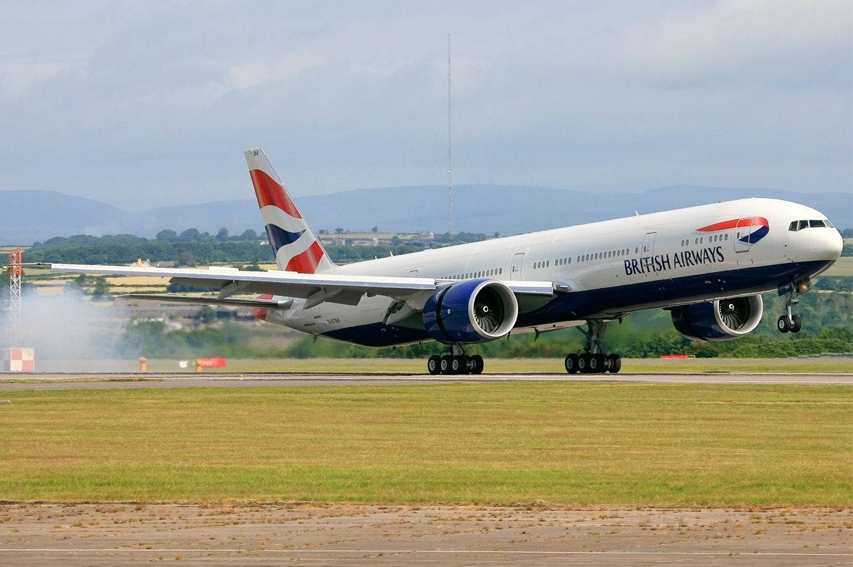 飛機 桌布 壁紙 — 英國航空波音777在陰天中從跑道起飛，輪胎後方冒出煙霧。