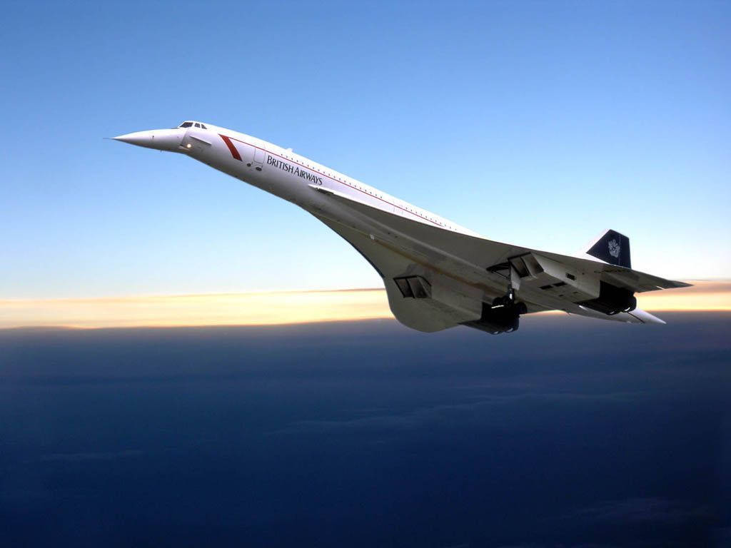 飛機 桌布 壁紙 — 英國航空的和諧式客機在日落時分翱翔於雲層之上，天空由藍色漸變至金橙色。