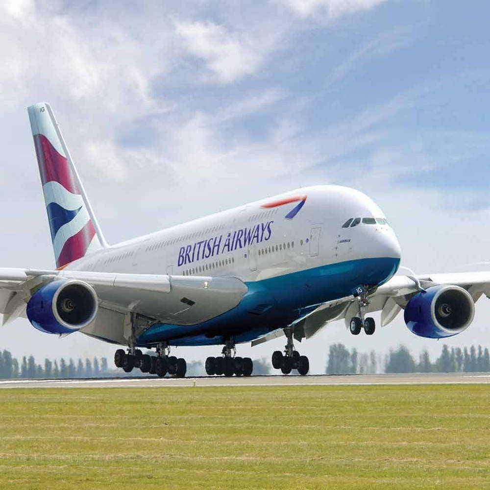 飛機 桌布 壁紙 — 英國航空的空中巴士A380從一條有綠色草地和樹木的跑道起飛，天空部分多雲，呈藍色。