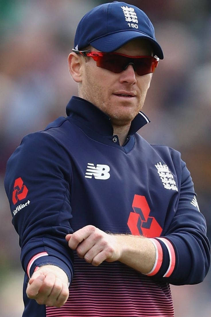 eoin morgan 桌布 壁紙 — 英格蘭板球隊隊長在比賽中專注地戴著海軍藍帽子和太陽眼鏡。