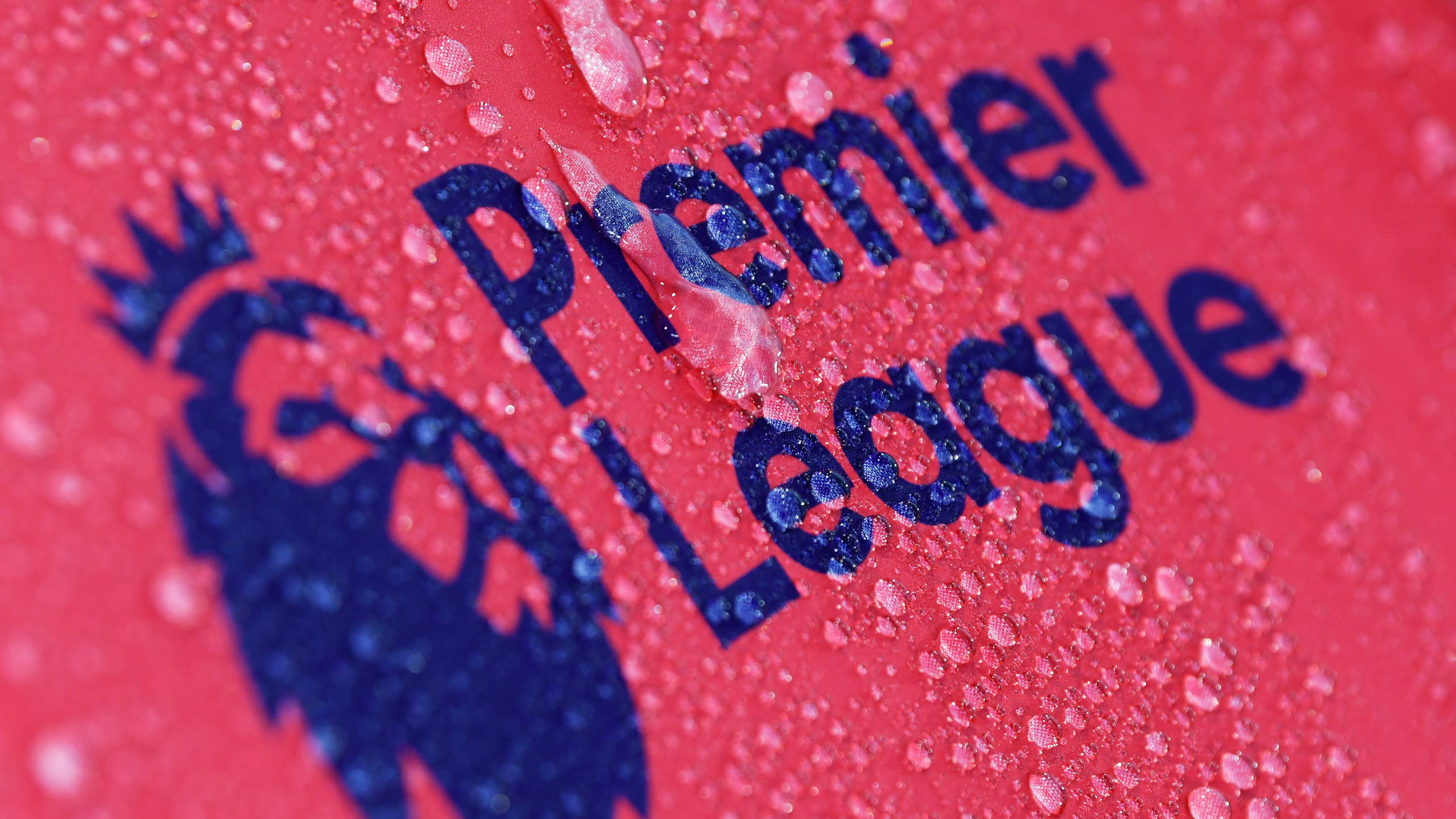 Premier 桌布 壁紙 — 英超聯賽標誌特寫，水珠在鮮紅色表面上閃閃發光。