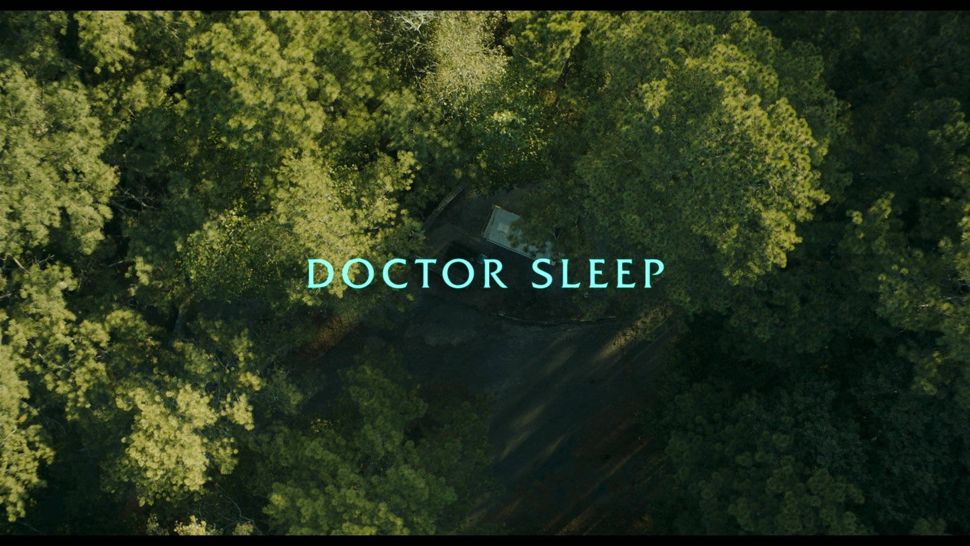 doctor sleep 桌布 壁紙 — 茂密綠色森林樹冠的鳥瞰圖，標題文字 Doctor Sleep 居中於一條隱藏小徑上方。